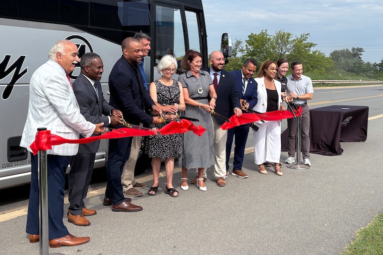 Delegates, senators, state officials, and Tradepoint representatives cut the ribbon on the new 411T commuter bus.