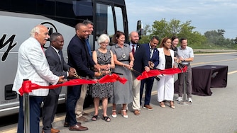 Delegates, senators, state officials, and Tradepoint representatives cut the ribbon on the new 411T commuter bus.