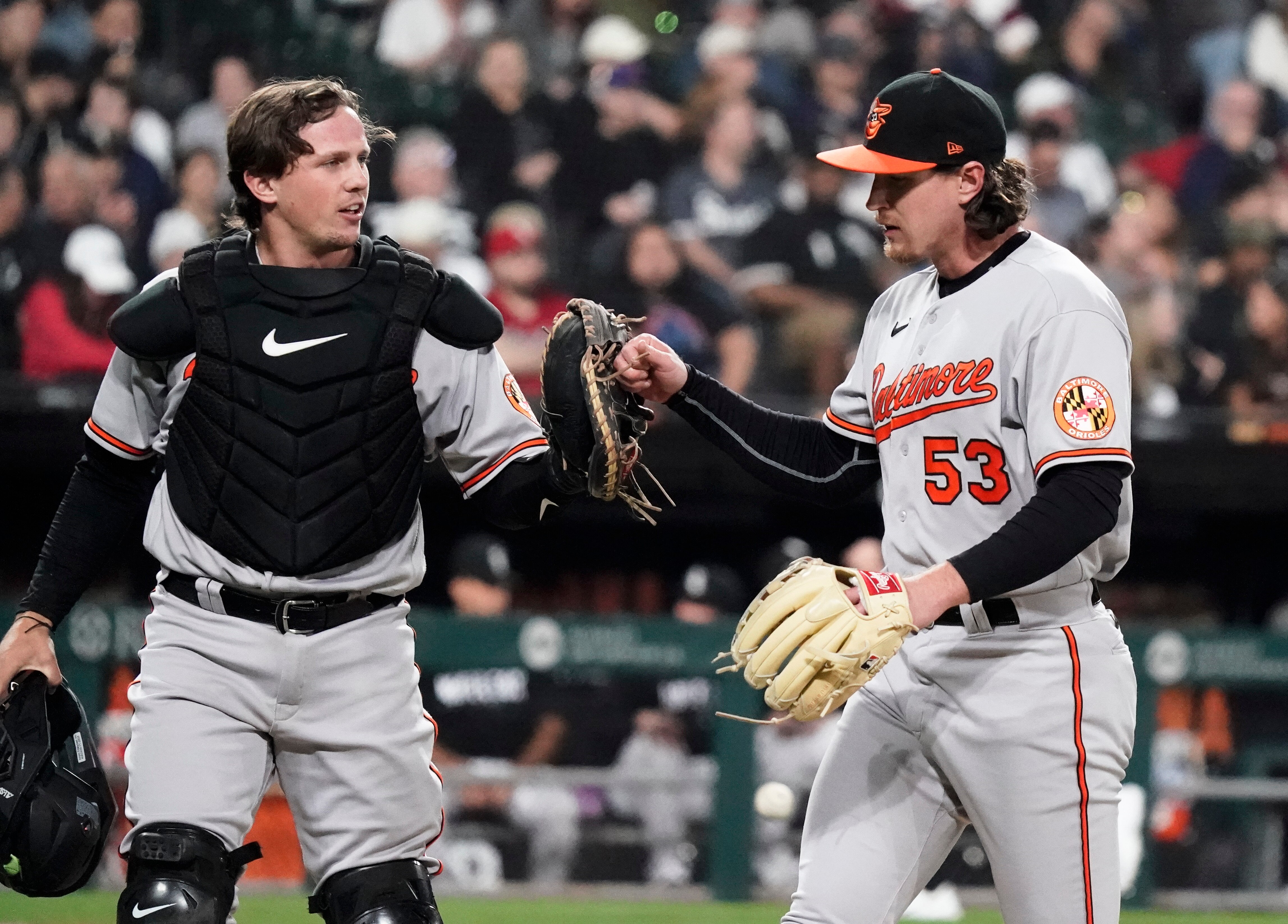 Adley Rutschman #35 and Mike Baumann #53 of the Baltimore Orioles react at the end of the sixth inning against the Chicago White Sox at Guaranteed Rate Field on April 14, 2023 in Chicago, Illinois.