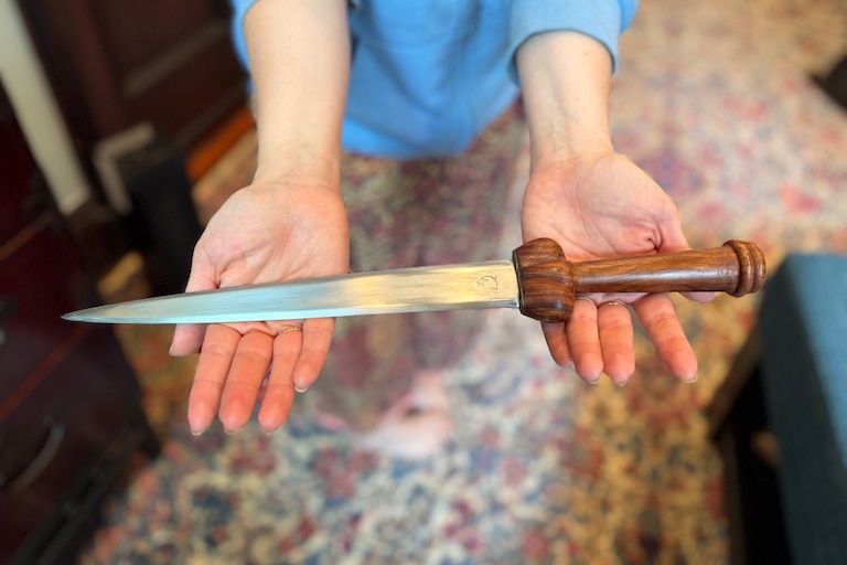 Rachel Cooper used a decorative knife that was hanging on the wall of her Bolton Hill home to fight off an intruder early Friday, May 8. Cooper holds the knife in her kitchen as she describes the attack on Sunday, May 10.