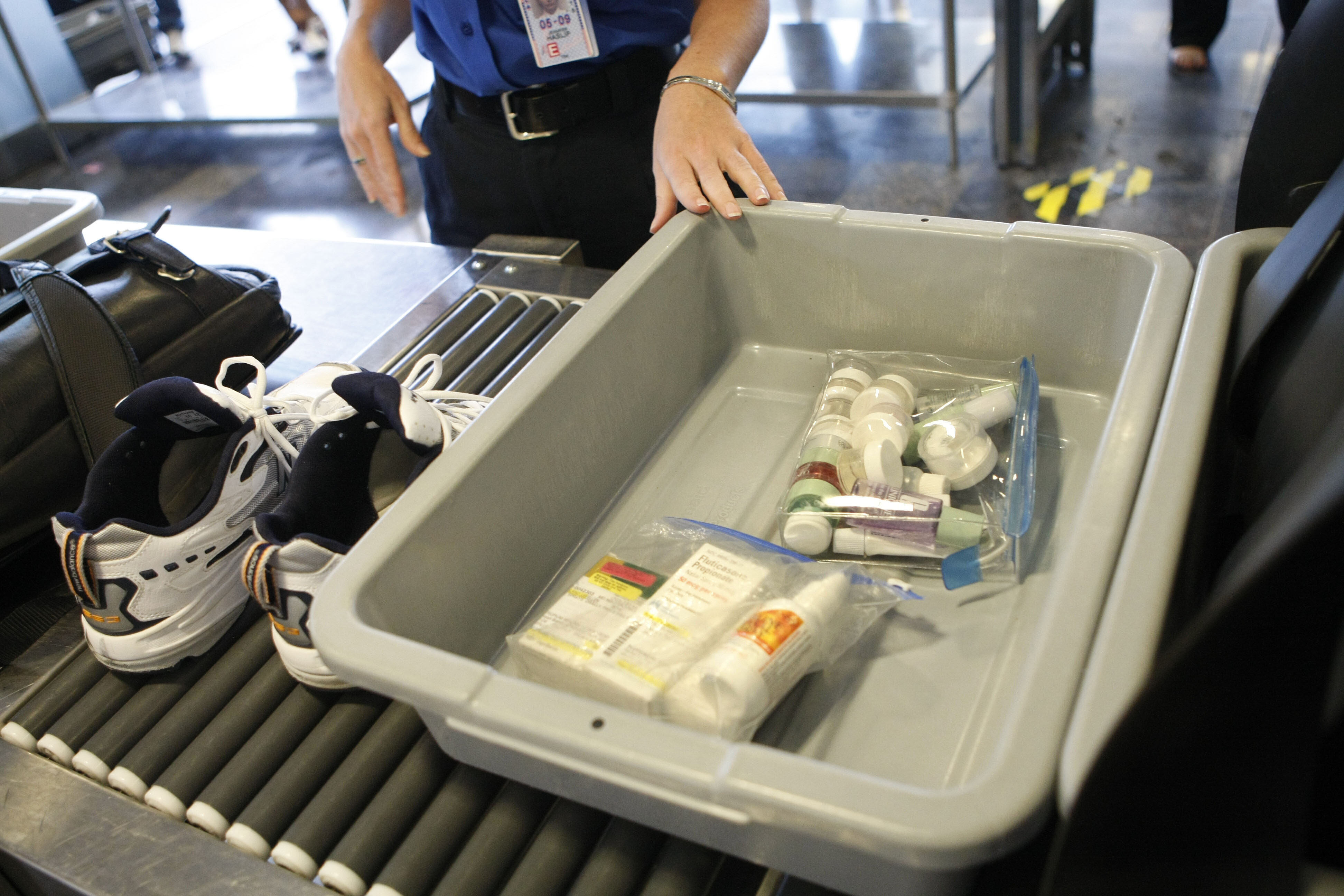 FILE - Shoes and small liquid containers are placed in bins to be screened by TSA Supervisor Jennifer Haslip at Washington's Ronald Reagan National Airport, June 27, 2008.