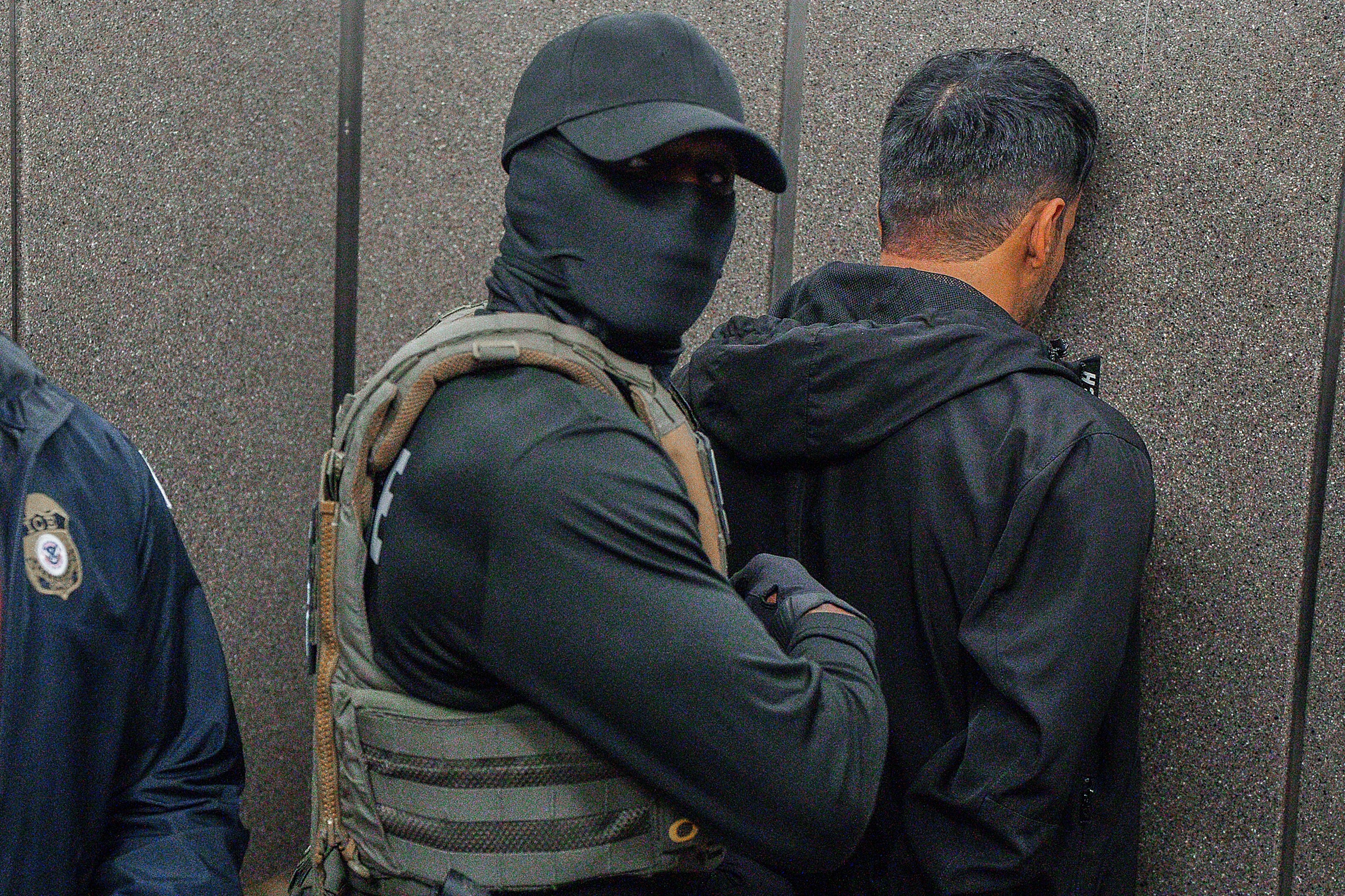 Immigration and Customs Enforcement agents escort a detained immigrant into an elevator after he exited an immigration courtroom.