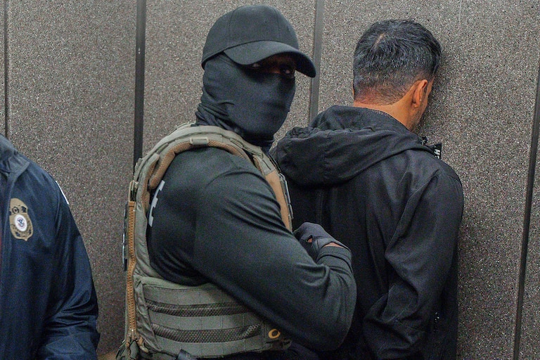 Immigration and Customs Enforcement agents escort a detained immigrant into an elevator after he exited an immigration courtroom.