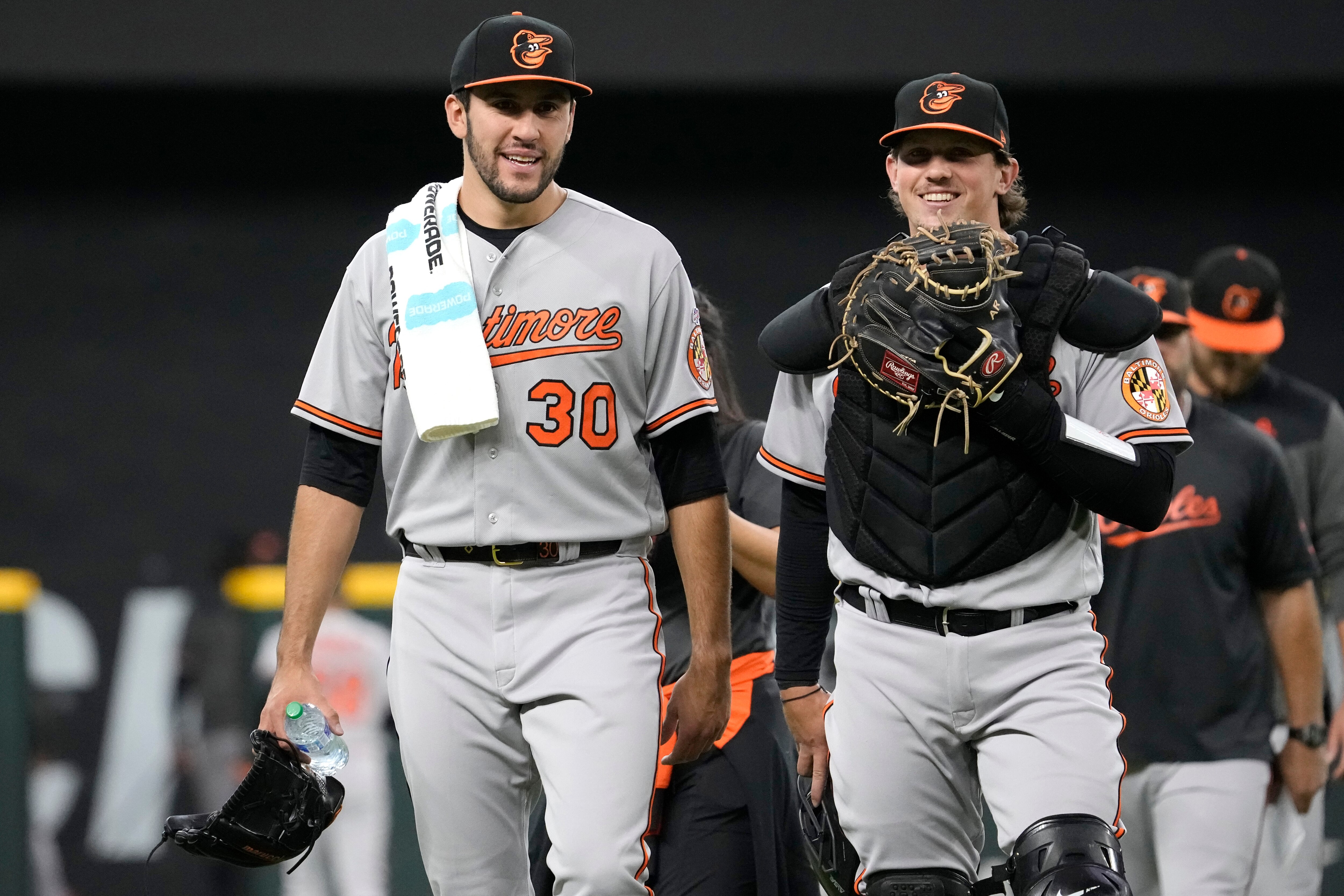 ARLINGTON, TEXAS - APRIL 05: Grayson Rodriguez #30 of the Baltimore Orioles and Adley Rutschman #35 walk back to the dugout ahead of Rodriguez' Major League debut game against the Texas Rangers  at Globe Life Field on April 05, 2023 in Arlington, Texas.