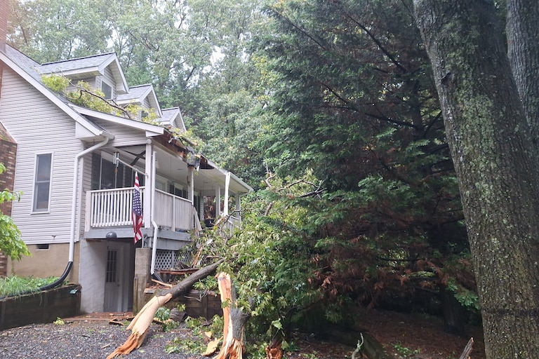 A large tree crashed onto the front of a home in Pasadena during severe thunderstorms Saturday, July 18, 2026, damaging the roof and blocking the front entrance.