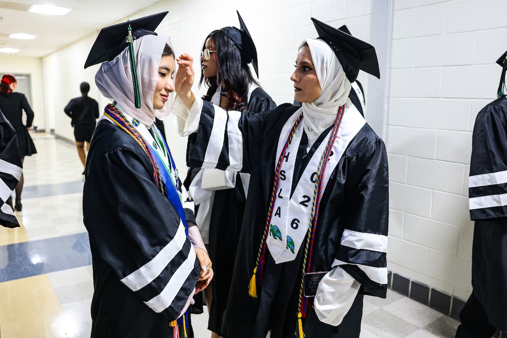 Class valedictorian Khatira Rustami, left, who came to the United States from Afghanistan at age 10 without speaking English, with her classmate and friend Khadija Babaee before their graduation from International High School at Largo in Upper Marlboro, Md.