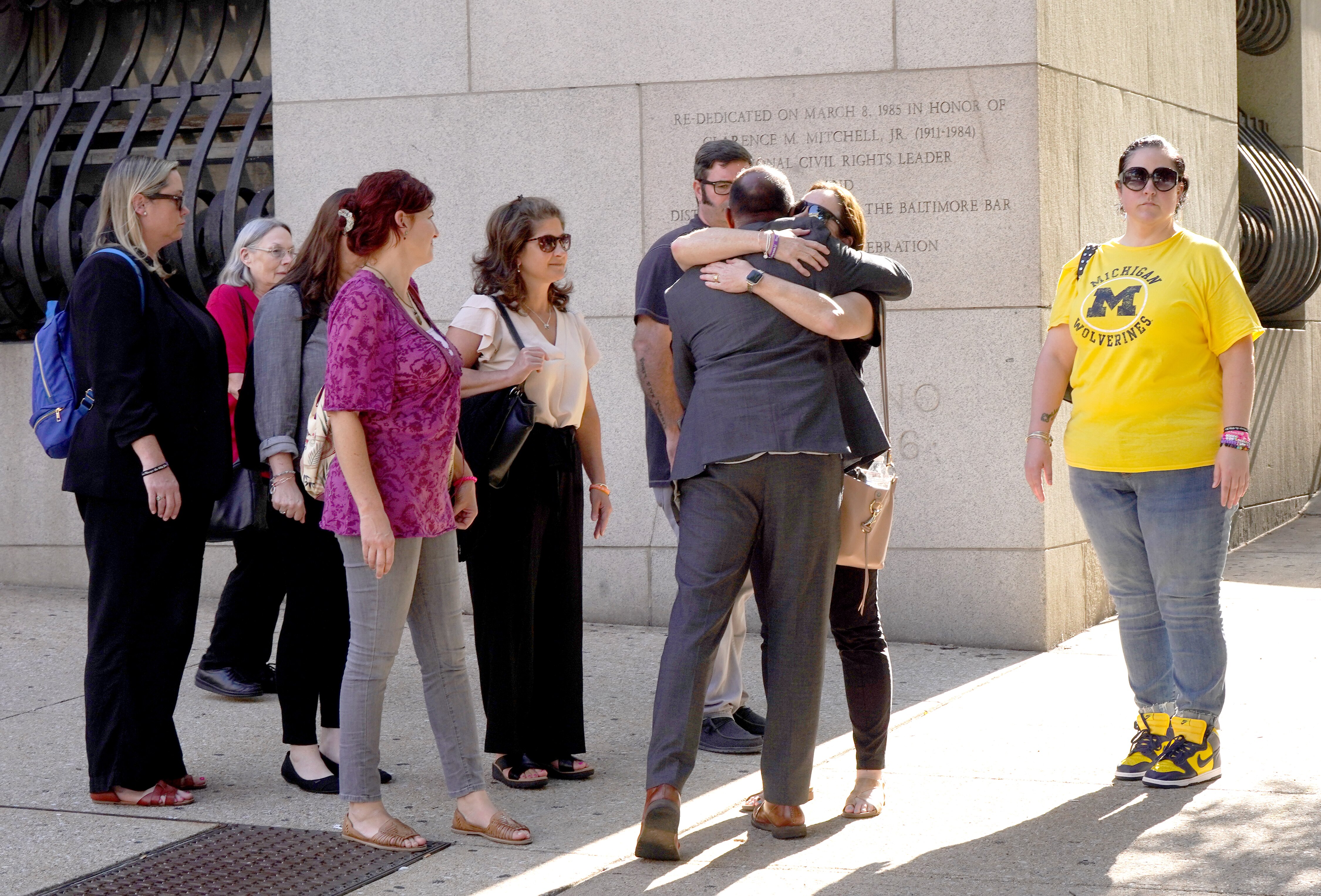 Becky Reynolds, far right, in yellow, and Shannon Reynolds, left center, in pink, leave the Clarence M. Mitchell Jr. Courthouse in Baltimore on Monday after a jury deliberated for almost three hours in the case of a 16-year-old charged with first-degree murder and related offenses. The teen is accusing of shooting and killing Timothy Reynolds, 48, of Hampden, at the intersection of Light and Conway streets near the Inner Harbor on July 7, 2022.