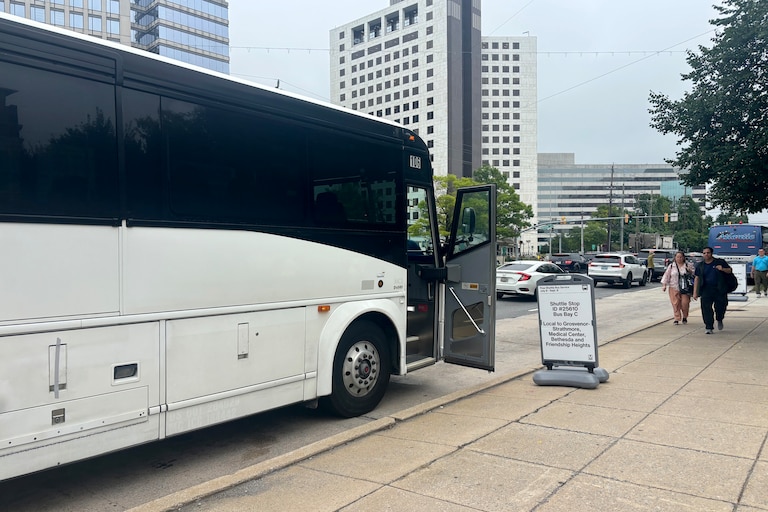 Metro commuters walk to a shuttle bus outside the North Bethesda Metro station.