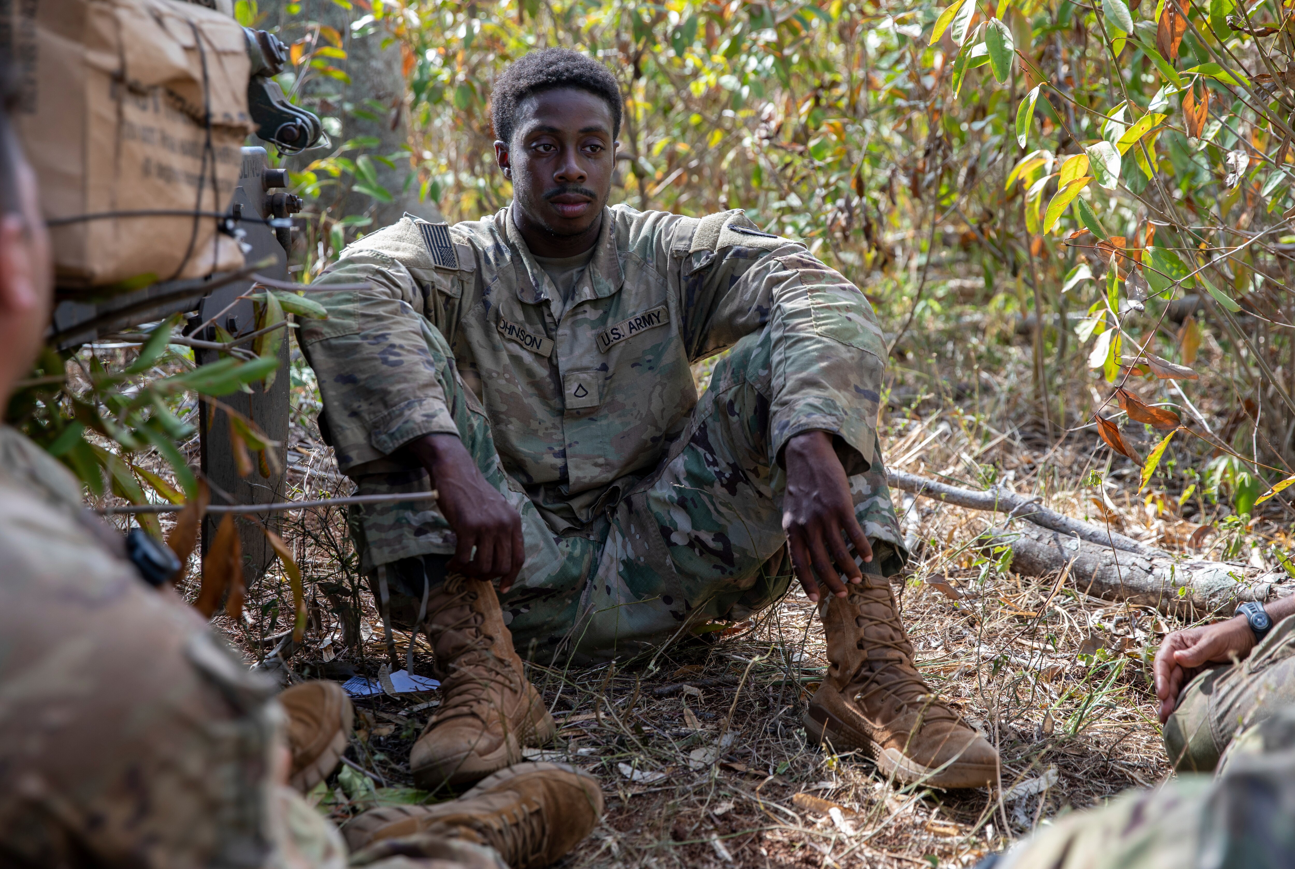 U.S. Army Pfc. Dewayne Johnson sits with his teammates during the Joint Pacific Multinational Readiness Center 24-01 at Helemano Military Reservation in Wahiawa, Hawaii, Nov. 2, 2023.