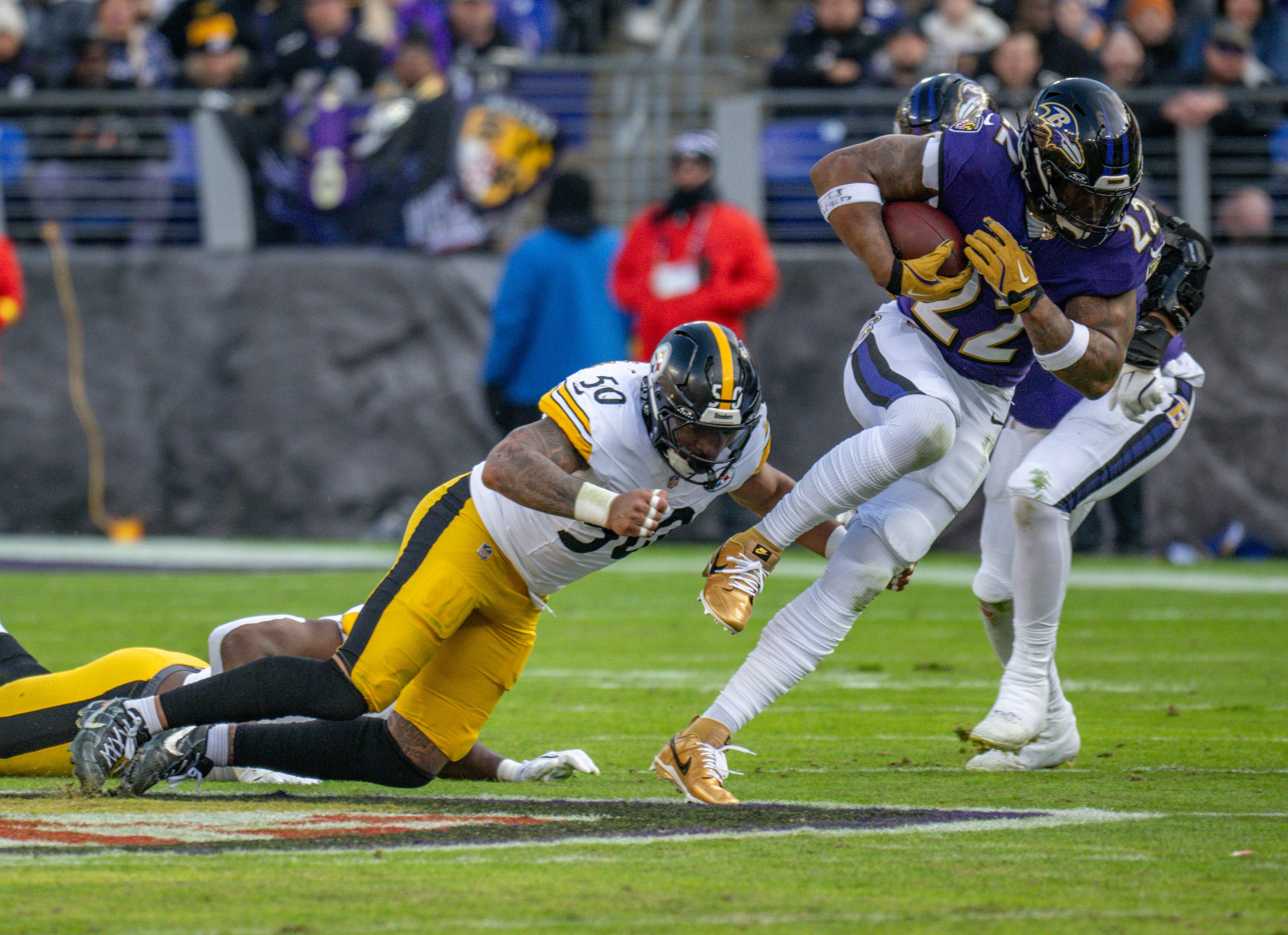 Baltimore Ravens running back Derrick Henry gets past Pittsburgh Steelers linebacker Malik Harrison for a first down in the second quarter of Sunday's game.