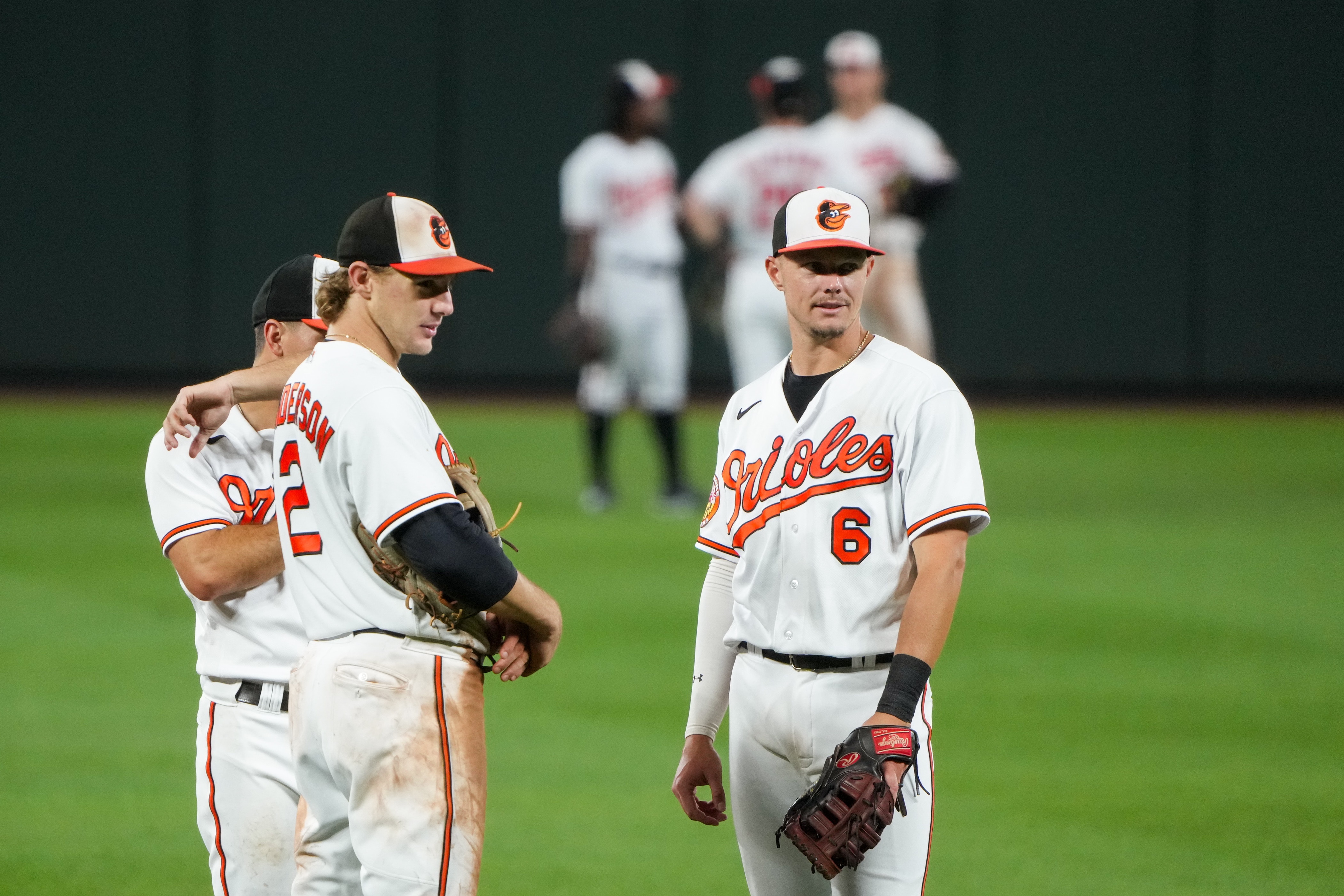 Baltimore Orioles infielders Ryan Mountcastle (6), Gunnar Henderson (2) and Ramón Urías (29) talk during a pitching change at a baseball game against the Chicago White Sox at Camden Yards on Monday, Aug. 28.