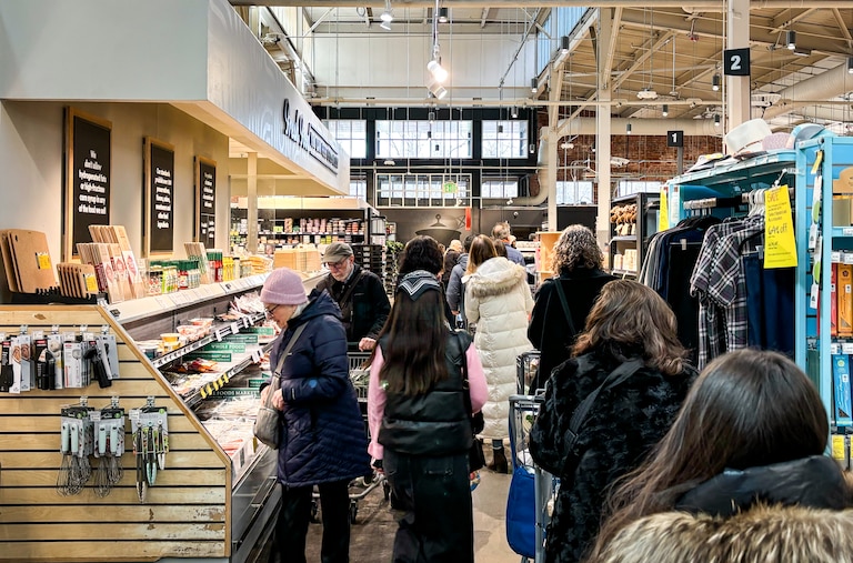 Shoppers wait in a long line to buy groceries at the Whole Foods Market in Baltimore's Mt. Washington neighborhood on Friday morning.