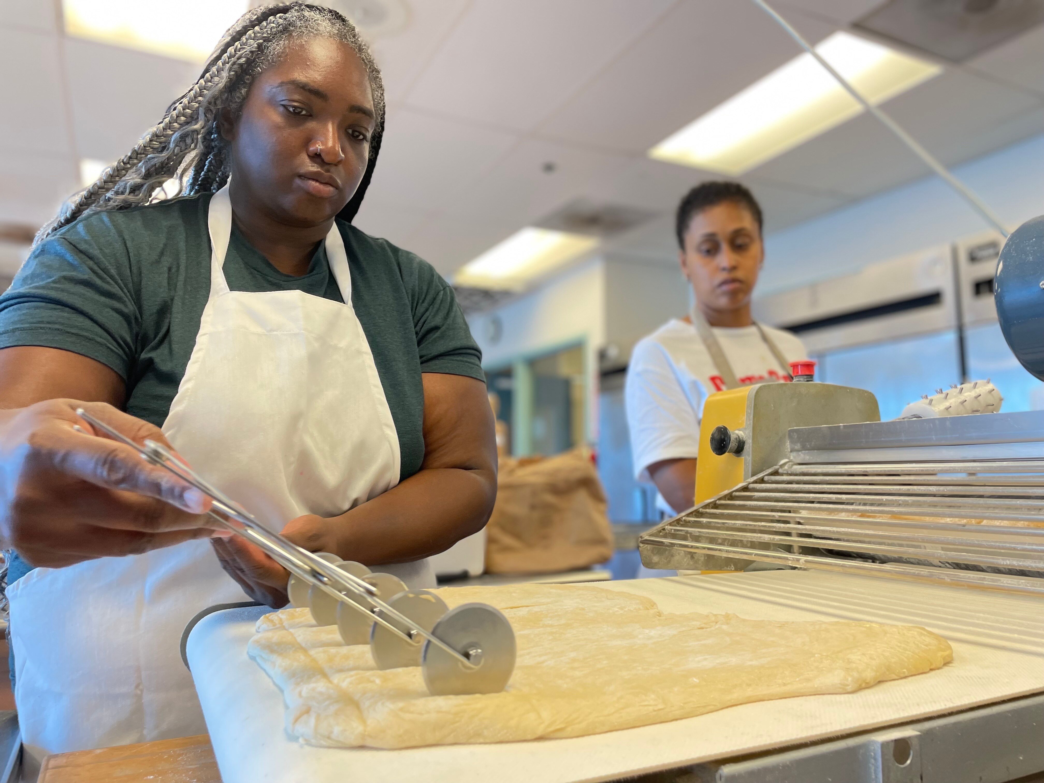 Beye Beignets co-owners Amber Croom, left, and Yassmeen Haskins prepare the dough for their signature creations in a kitchen inside the former Stratford University.