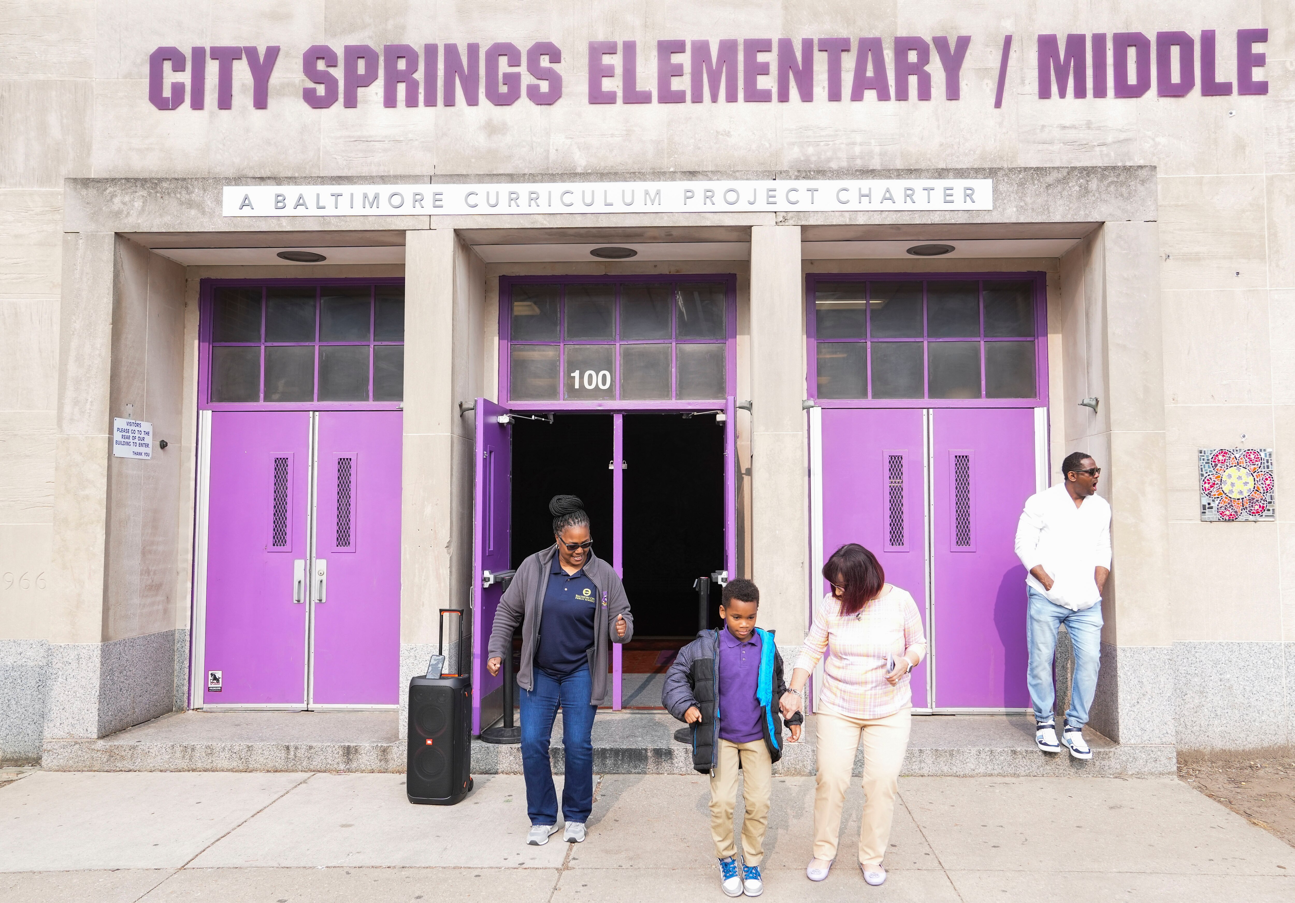 Manie Anthony dances alongside Rhonda Richetta, principal of City Springs School, outside the school building, Wednesday, May 10, 2023.