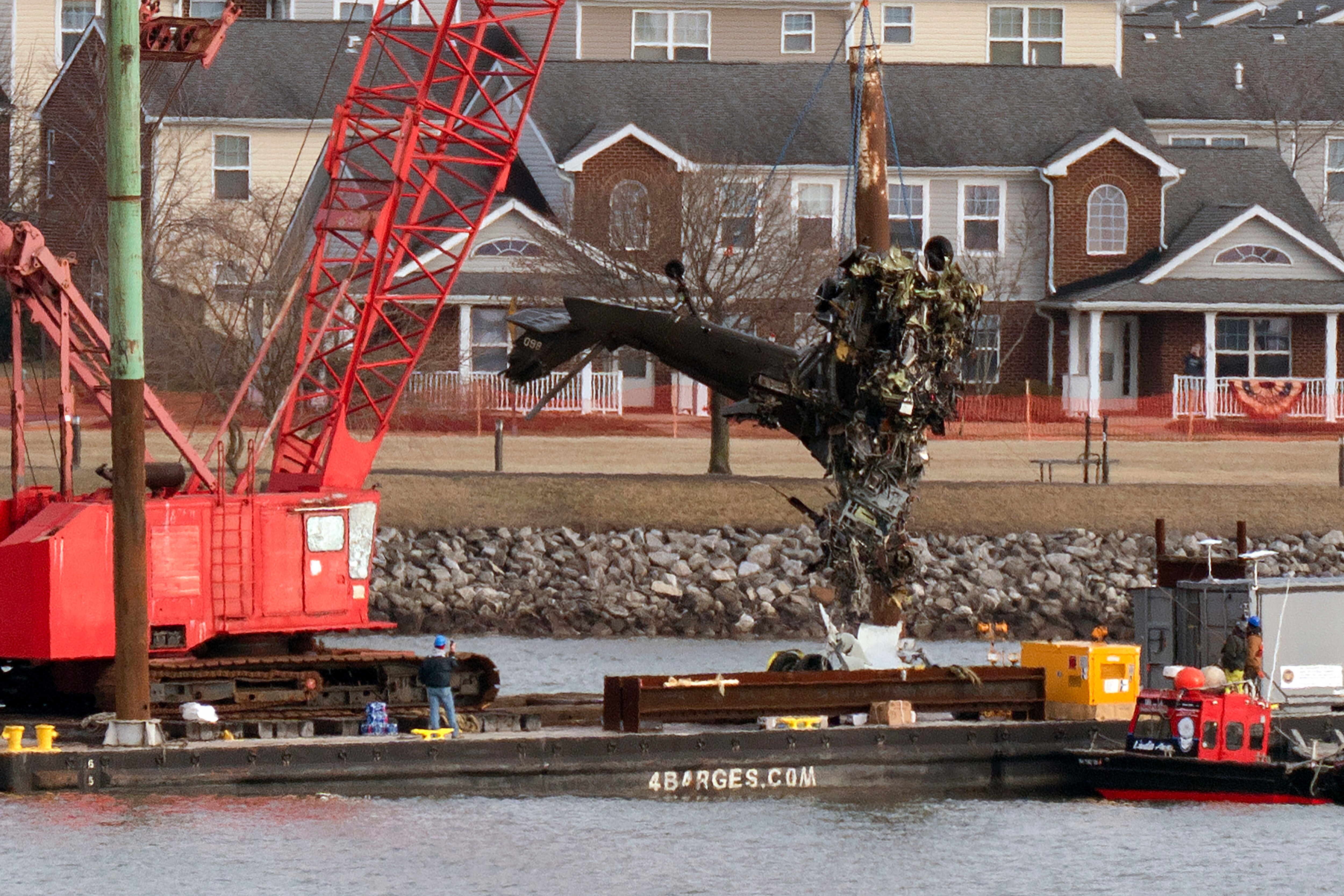FILE - Rescue and salvage crews pull up a part of a Army Black Hawk helicopter that collided midair with an American Airlines jet, at a wreckage site in the Potomac River from Ronald Reagan Washington National Airport, Feb. 6, 2025, in Arlington, Va. (AP Photo/Jose Luis Magana, File)