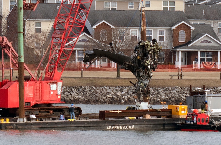 FILE - Rescue and salvage crews pull up a part of a Army Black Hawk helicopter that collided midair with an American Airlines jet, at a wreckage site in the Potomac River from Ronald Reagan Washington National Airport, Feb. 6, 2025, in Arlington, Va. (AP Photo/Jose Luis Magana, File)