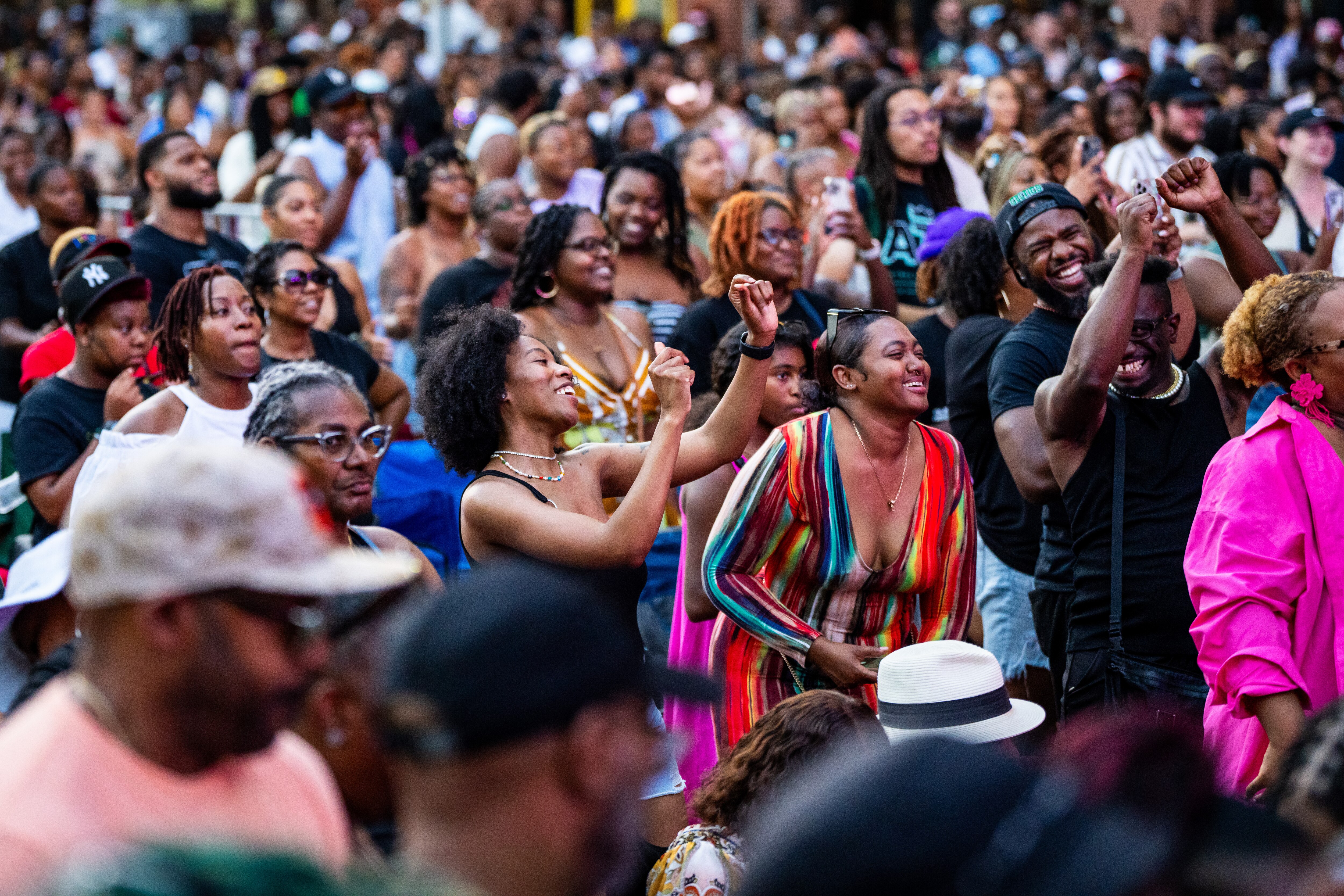 People dance and smile in the packed crowd.