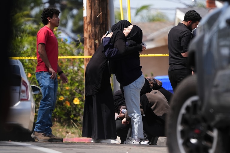 People embrace near the scene of a shooting outside the Islamic Center of San Diego Monday, May 18, 2026, in San Diego.
