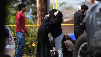 People embrace near the scene of a shooting outside the Islamic Center of San Diego Monday, May 18, 2026, in San Diego.