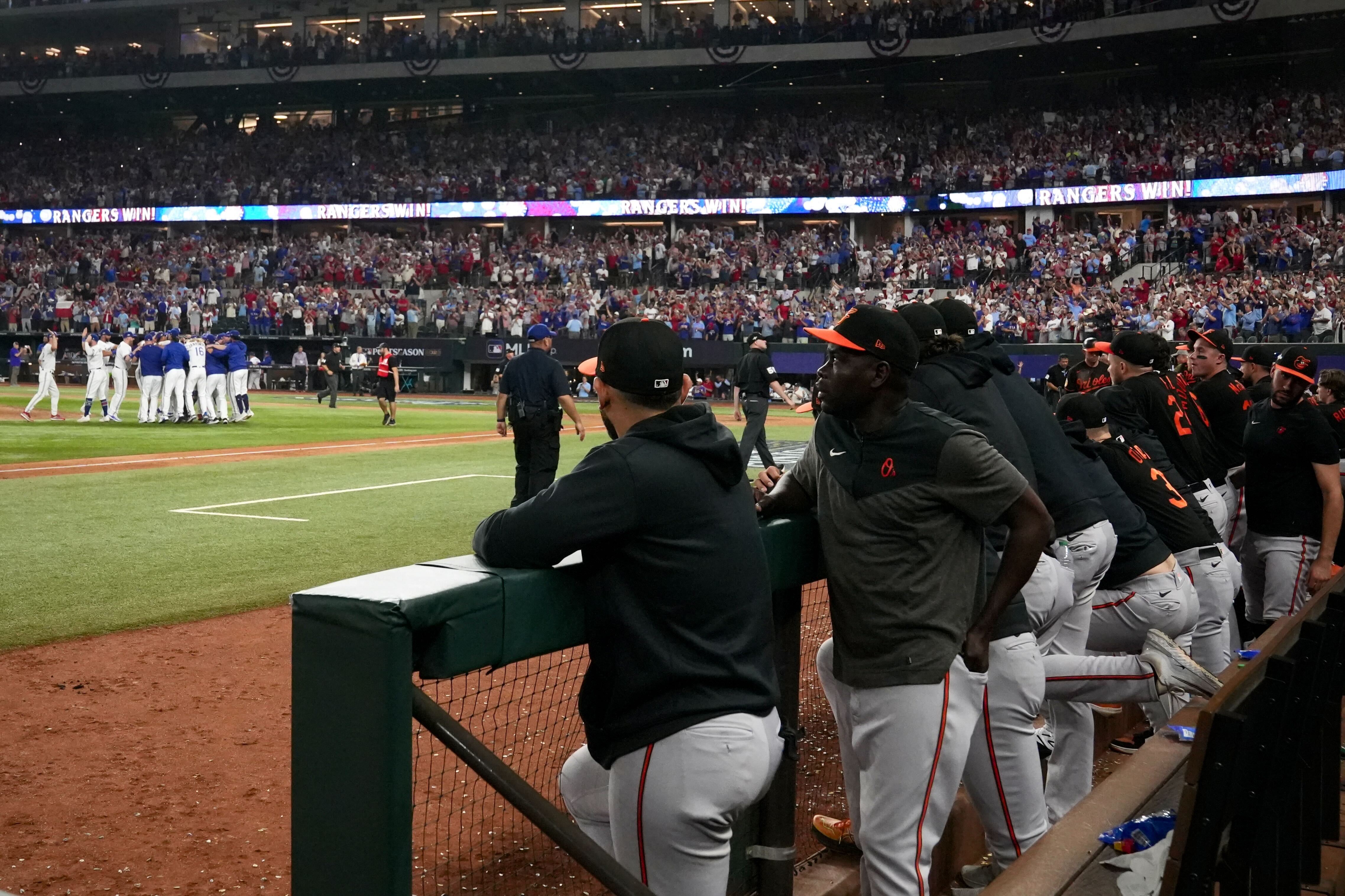 Orioles players and coaches watch as the Texas Rangers celebrate their three-game sweep of the ALDS.