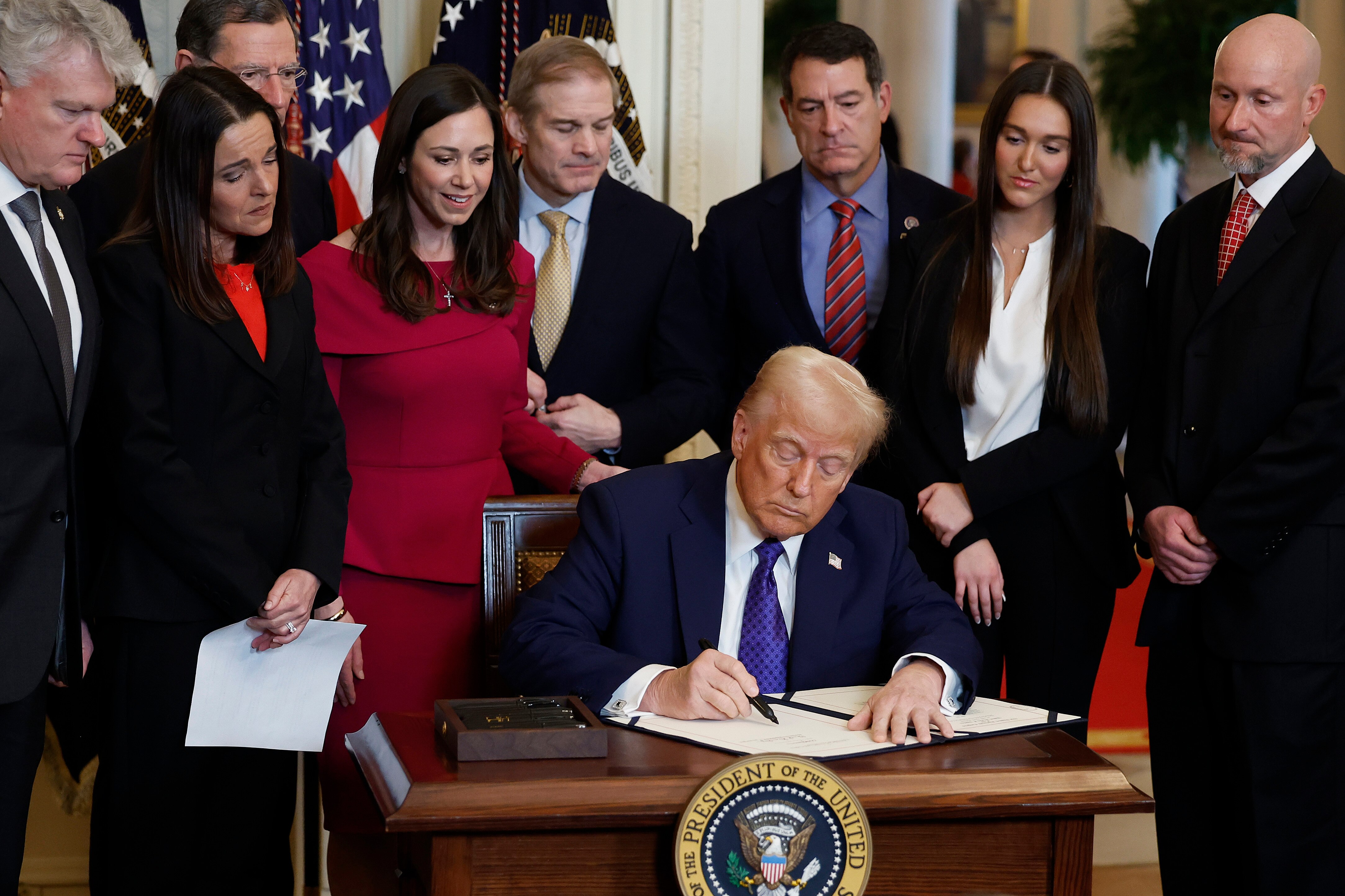 WASHINGTON, DC - JANUARY 29: Surrounded by members of Congress and the family of Laken Riley, U.S. President Donald Trump signs the Laken Riley Act, the first piece of legislation passed during his second term in office, in the East Room of the White House on January 29, 2025 in Washington, DC. Jason Riley and Allyson Philips, the parents of 22-year-old Laken Riley, a University of Georgia nursing student who was murdered in 2024 by an undocumented immigrant, attended the signing ceremony. Among other measures, the law directs law enforcement authorities to detain and deport immigrants who are accused but not yet convicted of specific crimes, if they are in the country illegally.  (Photo by Chip Somodevilla/Getty Images)
