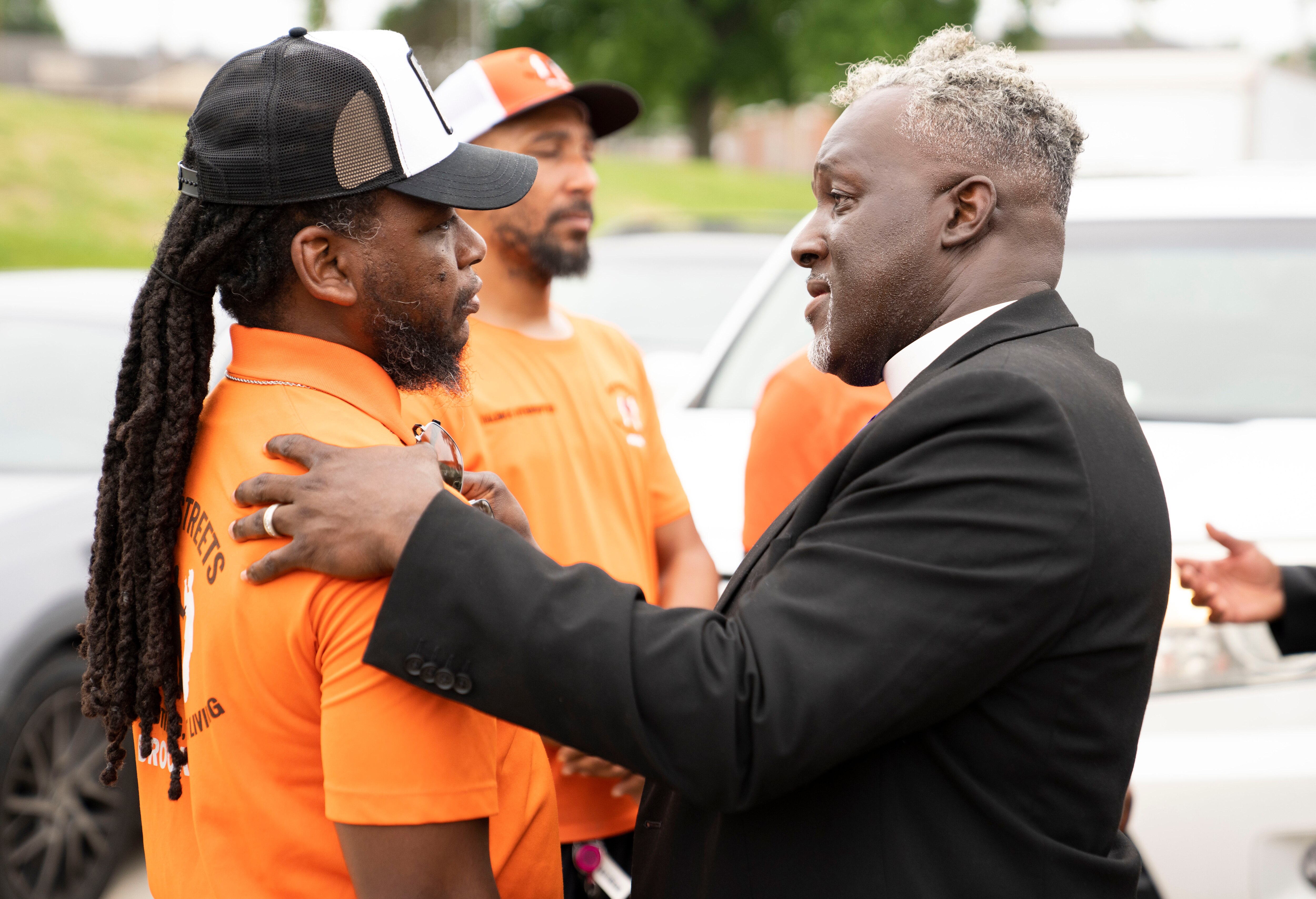 Bishop John Watts of Kingdom Life Church Apostolic greets a Safe Streets worker on July 2, following a shooting at Brooklyn Homes.