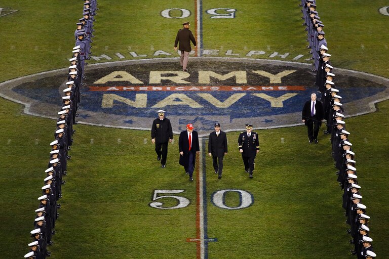 President Donald Trump and Secretary of Defense Mark Esper cross the field after the first half of an NCAA college football game between Army and Navy, Saturday, Dec. 14, 2019, in Philadelphia.