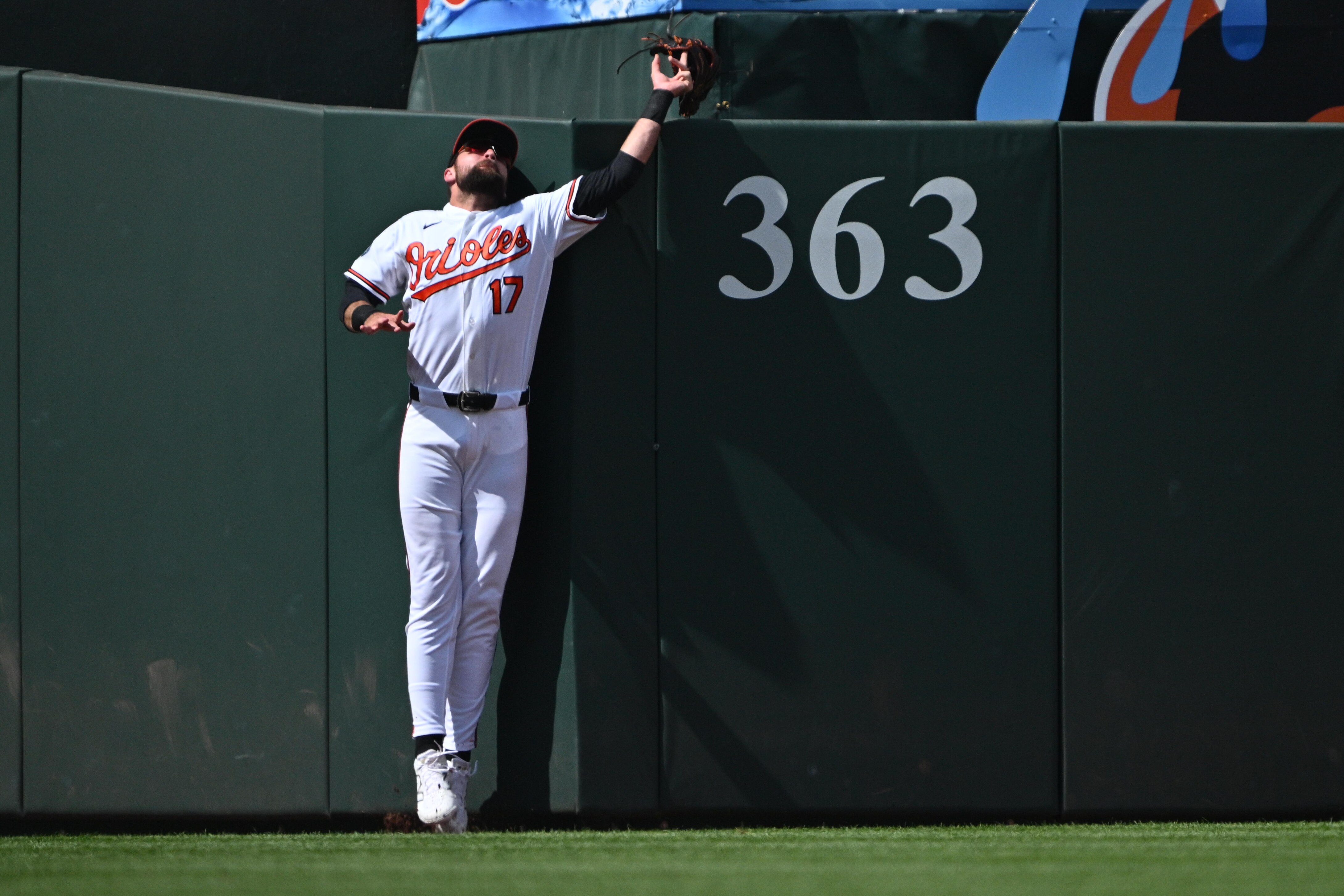 Colton Cowser loses his glove over the fence as he attempts to catch a home run by Jackson Merrill of the Padres in the first inning.