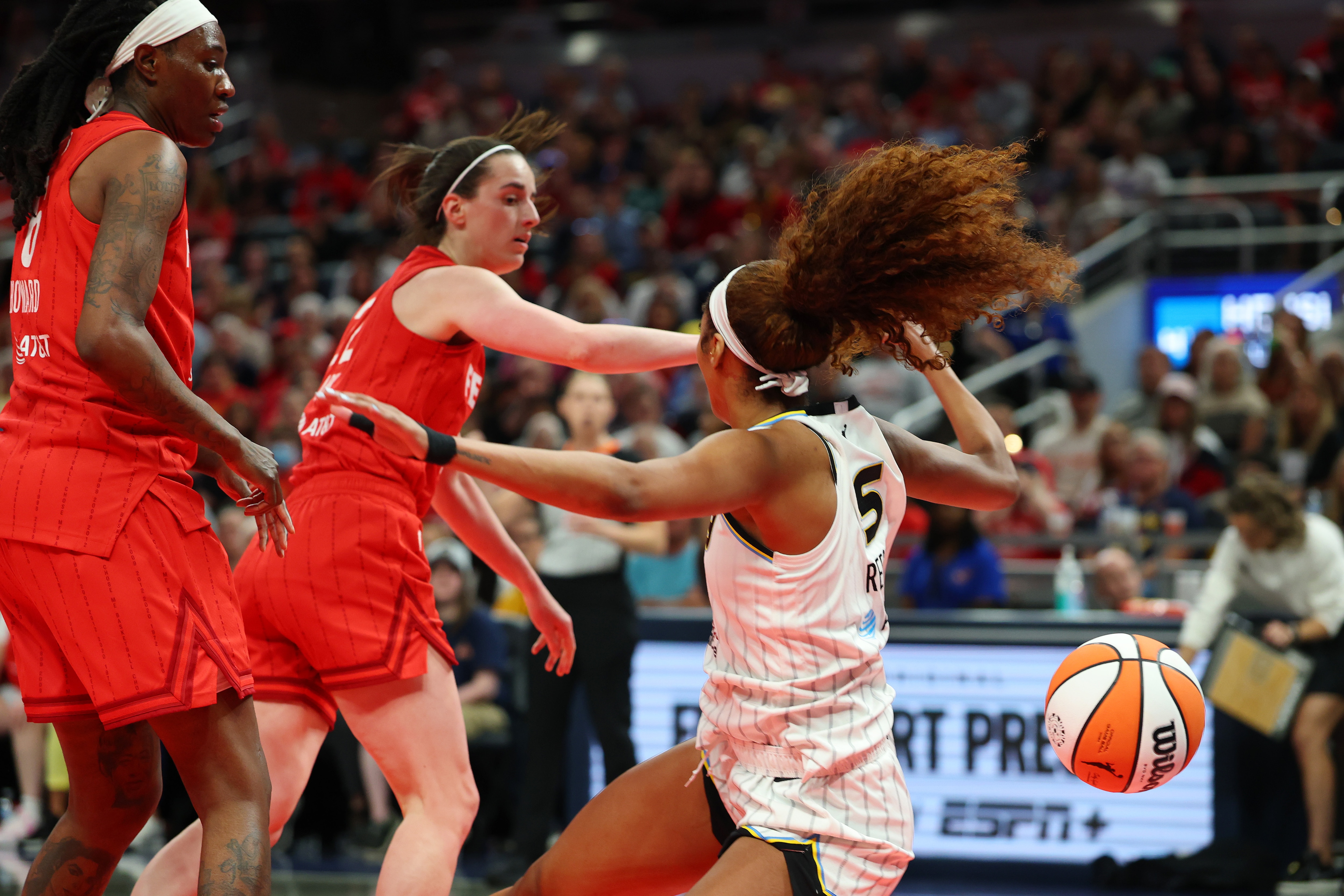 Angel Reese of the Chicago Sky takes a hard foul from Caitlin Clark of the Indiana Fever during the third quarter Sunday of the teams’ WNBA season opener.