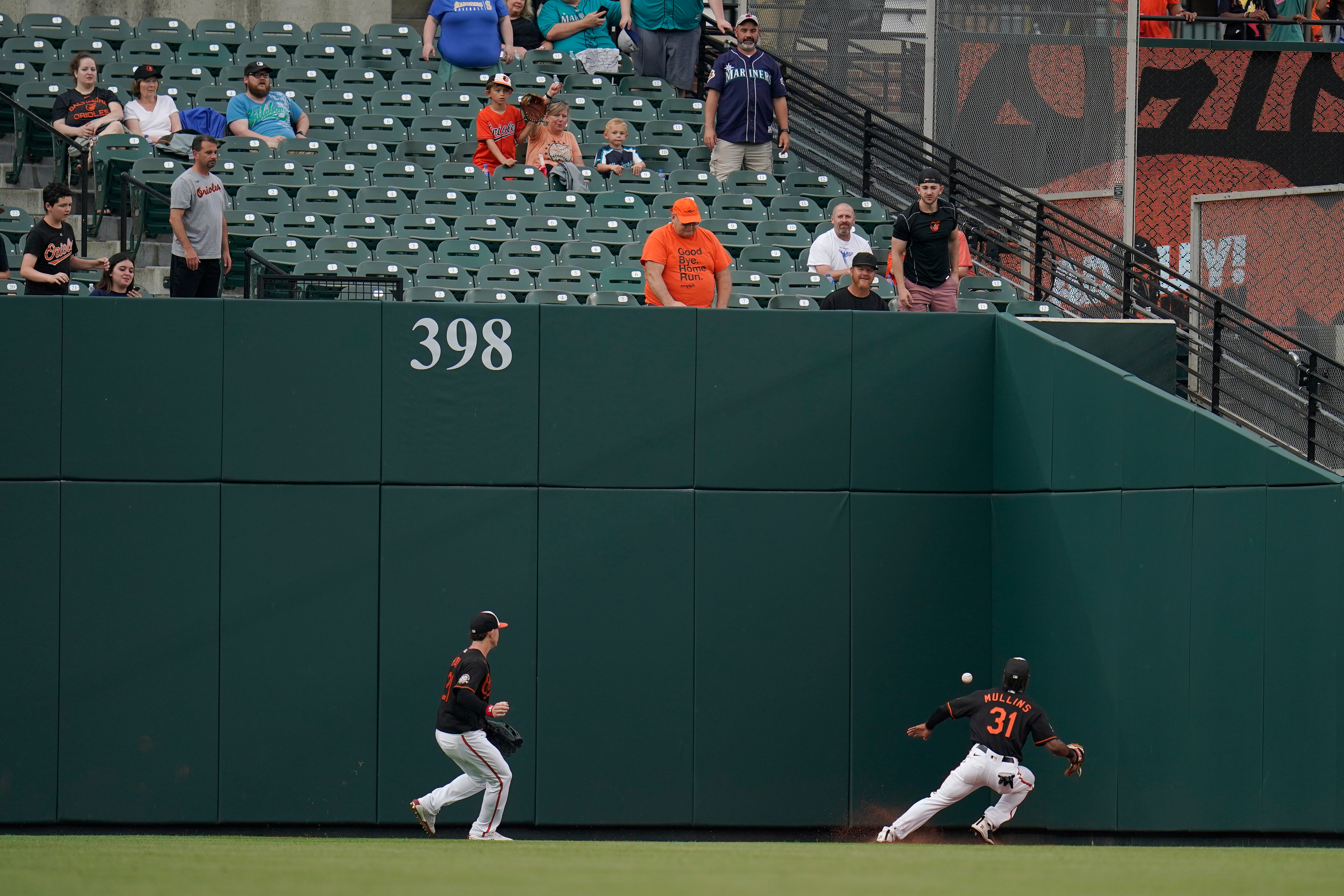 Orioles center fielder Cedric Mullins and left fielder Austin Hays chase a ball hit to the left field fence in a 2022 game.