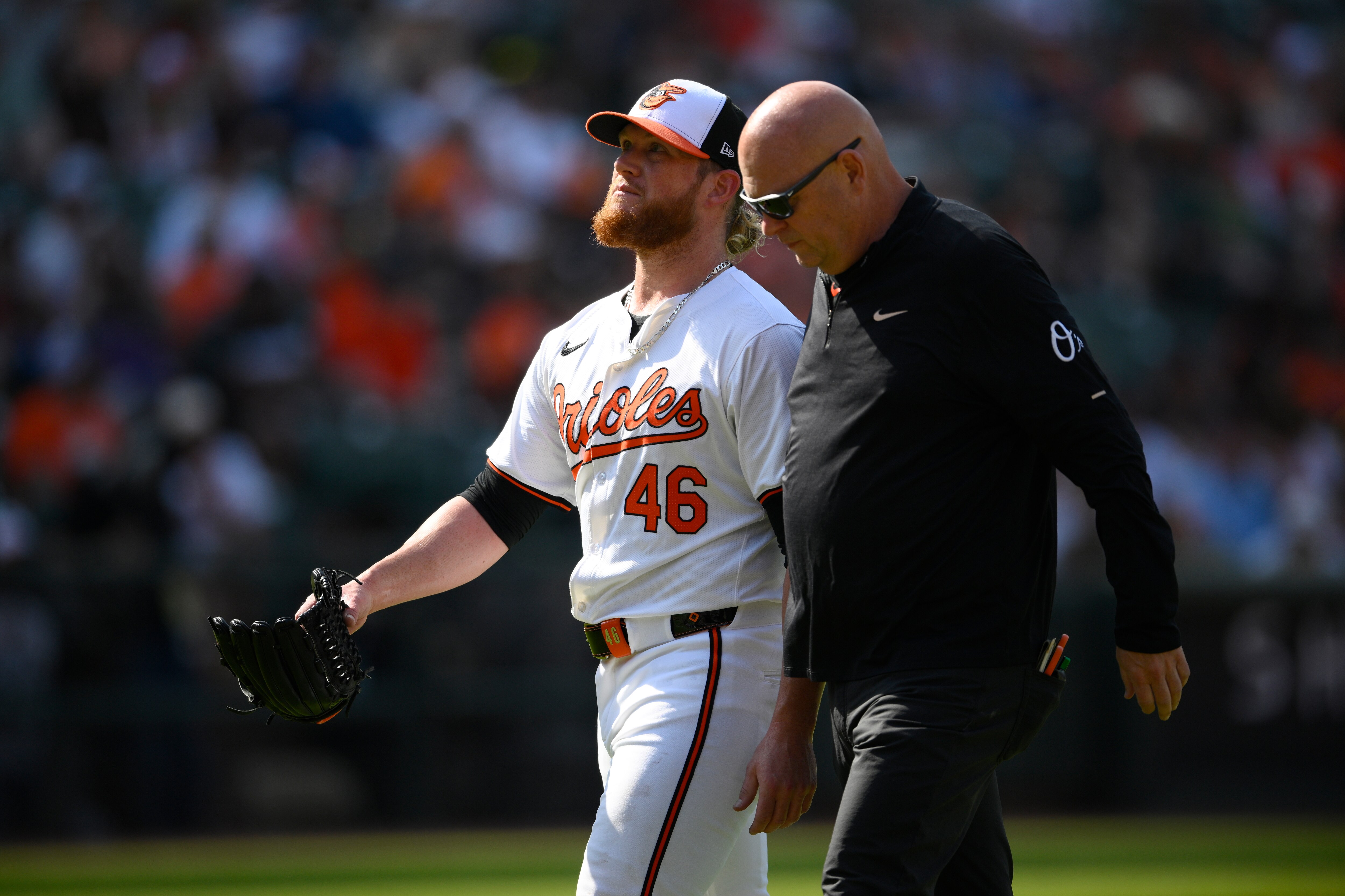 Baltimore Orioles relief pitcher Craig Kimbrel, left, leaves the game alongside trainer Brian Ebel, right, during the ninth inning against the Oakland Athletics.