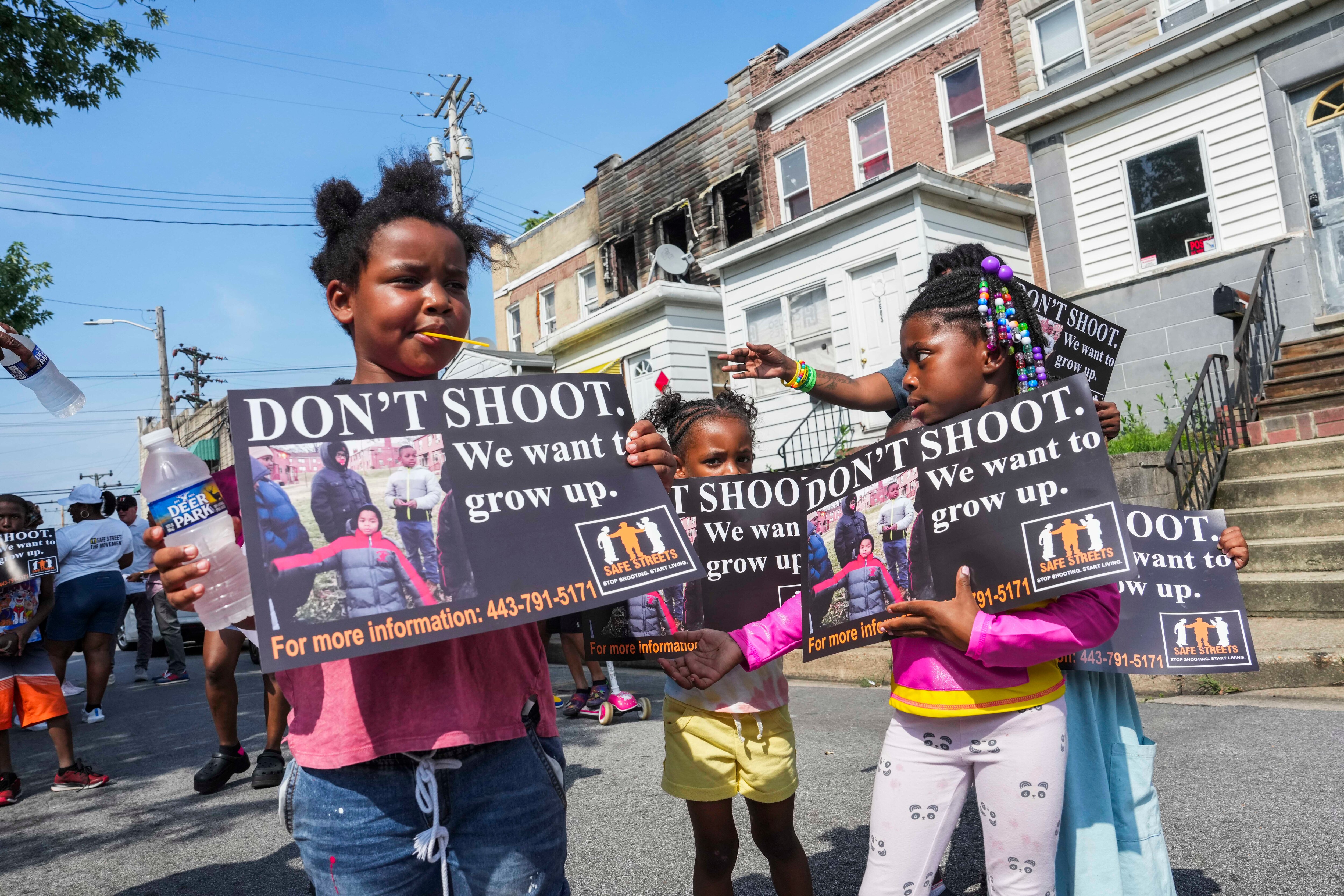 Kiran, 8, and Taylor, 6, hold up signs that say “DON’T SHOOT. We want to grow up.” during a Safe Streets peace walk on July 7, 2023 in Brooklyn. Gun violence such as the recent mass shooting in that South Baltimore neighborhood has a lasting effect on how many Baltimore young people view their lives, says Adam Schwartz, an author who has taught high school in Baltimore for 25 years.