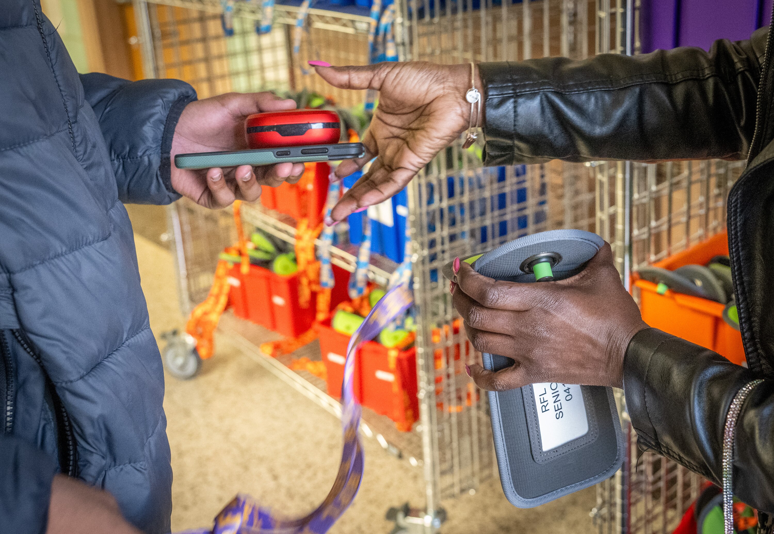 Principal Shawnette Williams collects a cellphone and headphones from a student arriving at Reginald Lewis High School in Baltimore. The school piloted a strict ban on cellphone use during the school day.