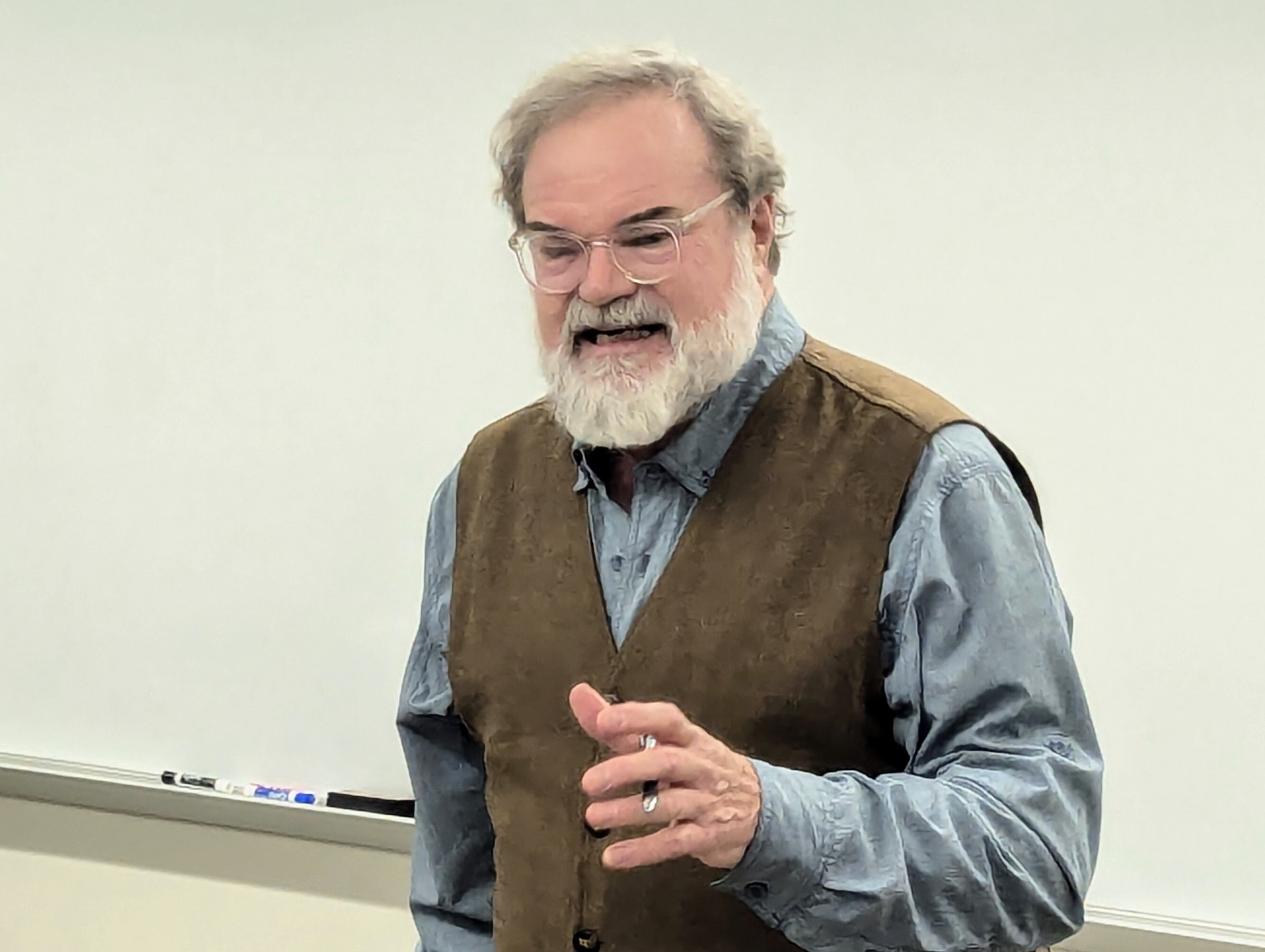 Annapolis Poet Laureate recites the ballad of Muskrat Greene, the oyster eating champion of Deale, to a group of seniors sharing poetry at Anne Arundel Community College on Dec. 13, 2024.