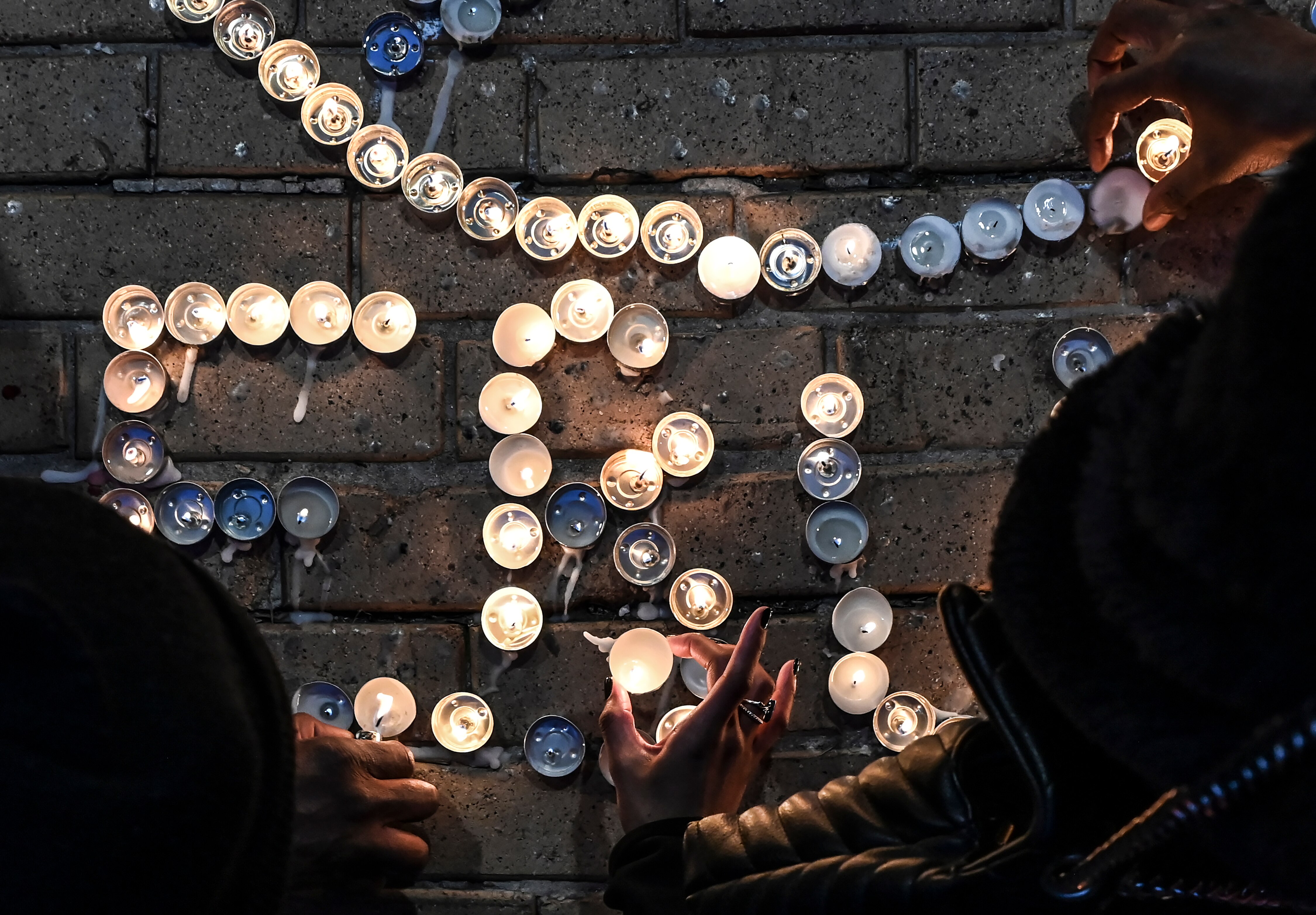 Friends and family of boxer Ernie "Lightening Bug" Hall attend a candlelight vigil at his gym, Lightning Quick Fit in Mount Vernon.