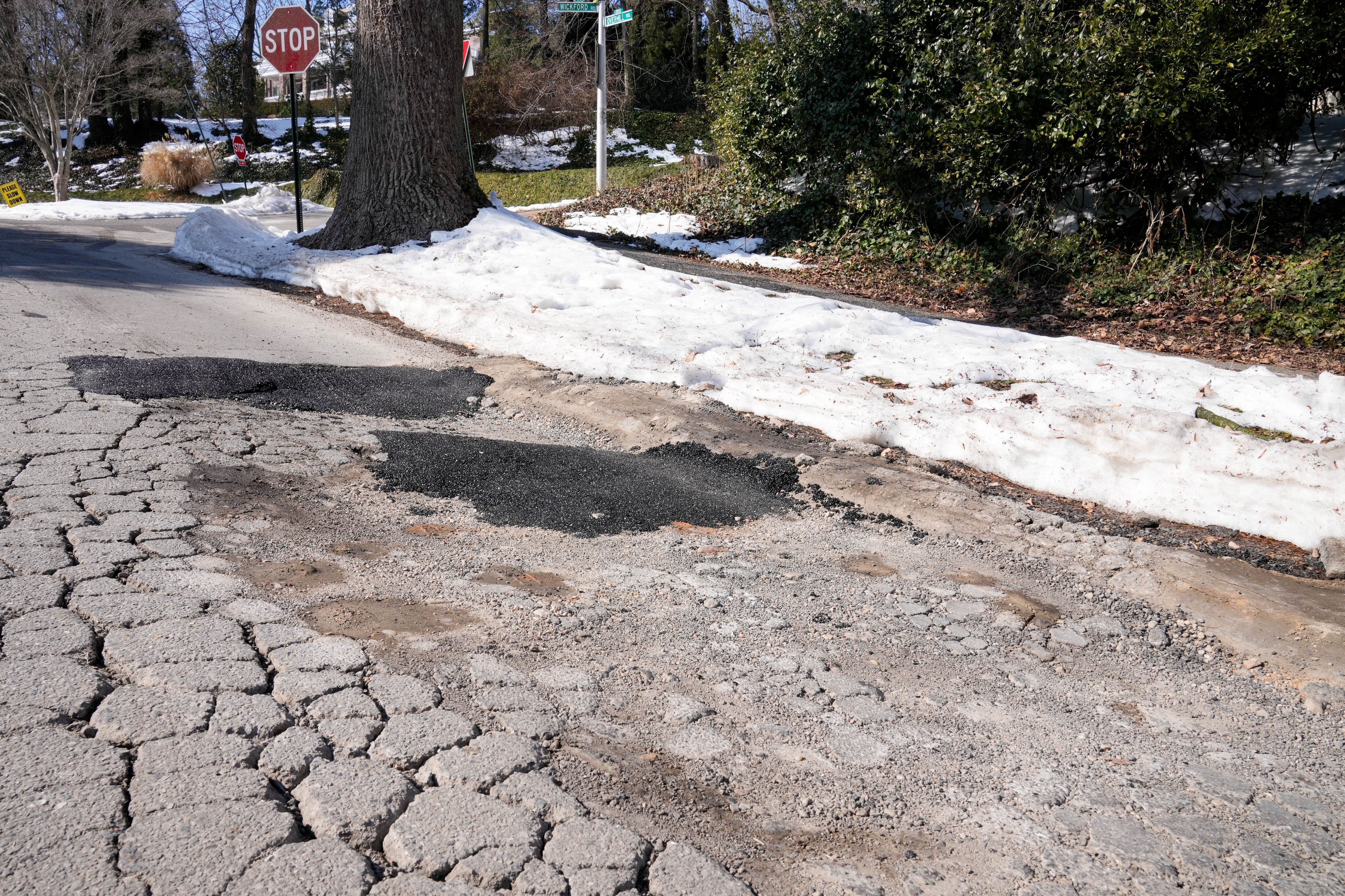 Road damage and potholes near the intersection of Wickford and Overhill roads in Baltimore.