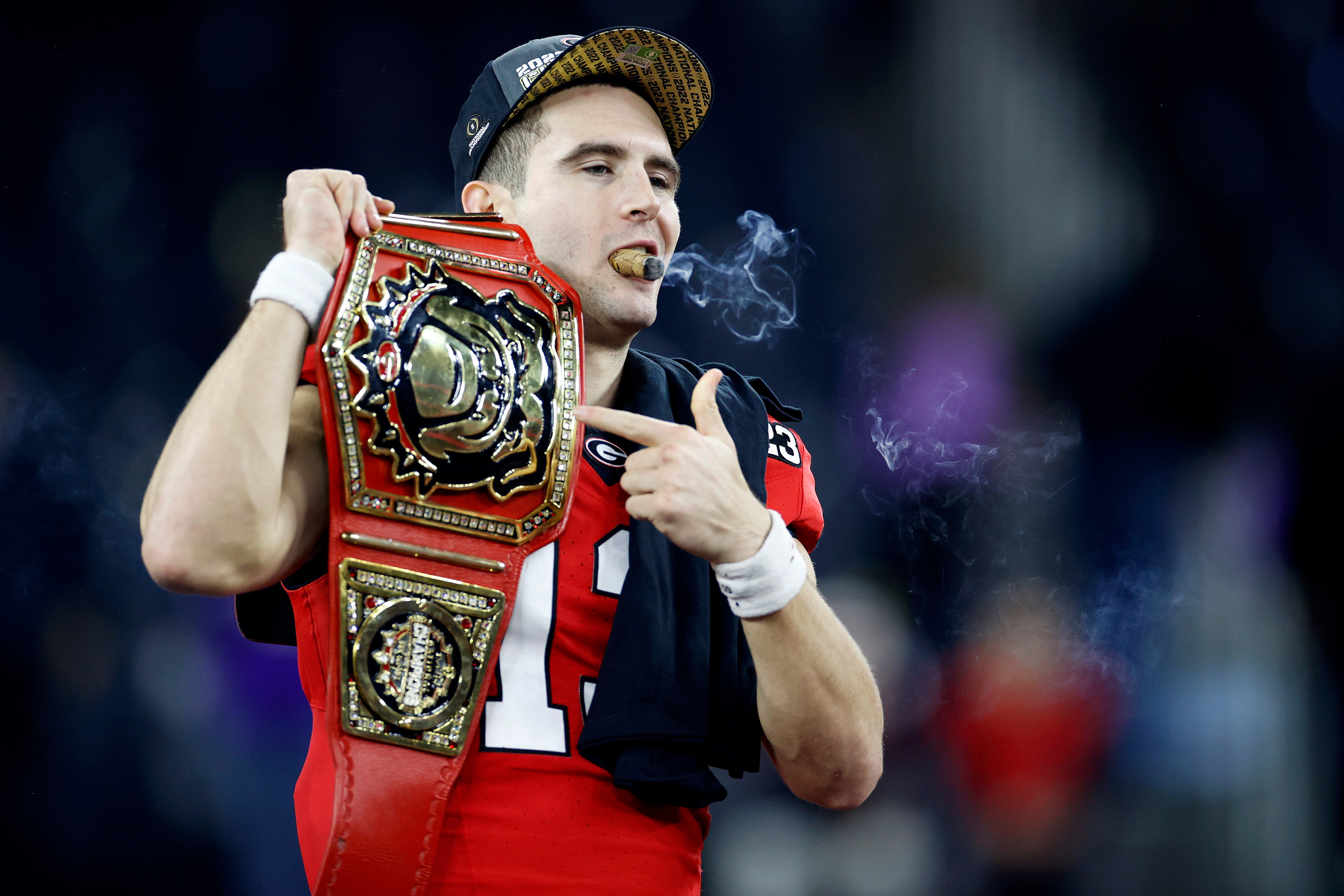 INGLEWOOD, CALIFORNIA - JANUARY 09: Stetson Bennett #13 of the Georgia Bulldogs celebrates with teammates and a cigar after defeating the TCU Horned Frogs in the College Football Playoff National Championship game at SoFi Stadium on January 09, 2023 in Inglewood, California. Georgia defeated TCU 65-7.