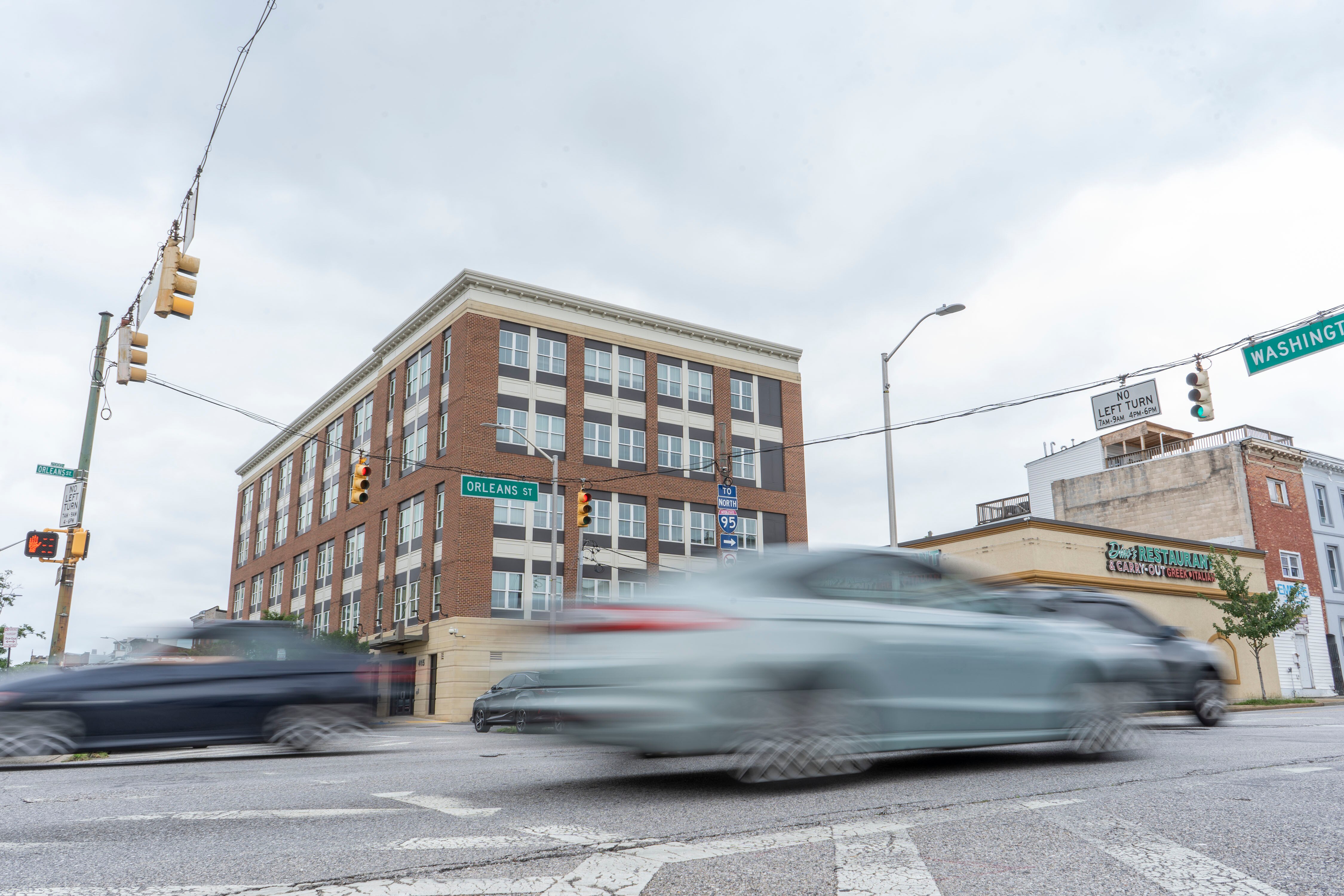Cars drive on Orleans Street near the Johns Hopkins East Baltimore Campus.