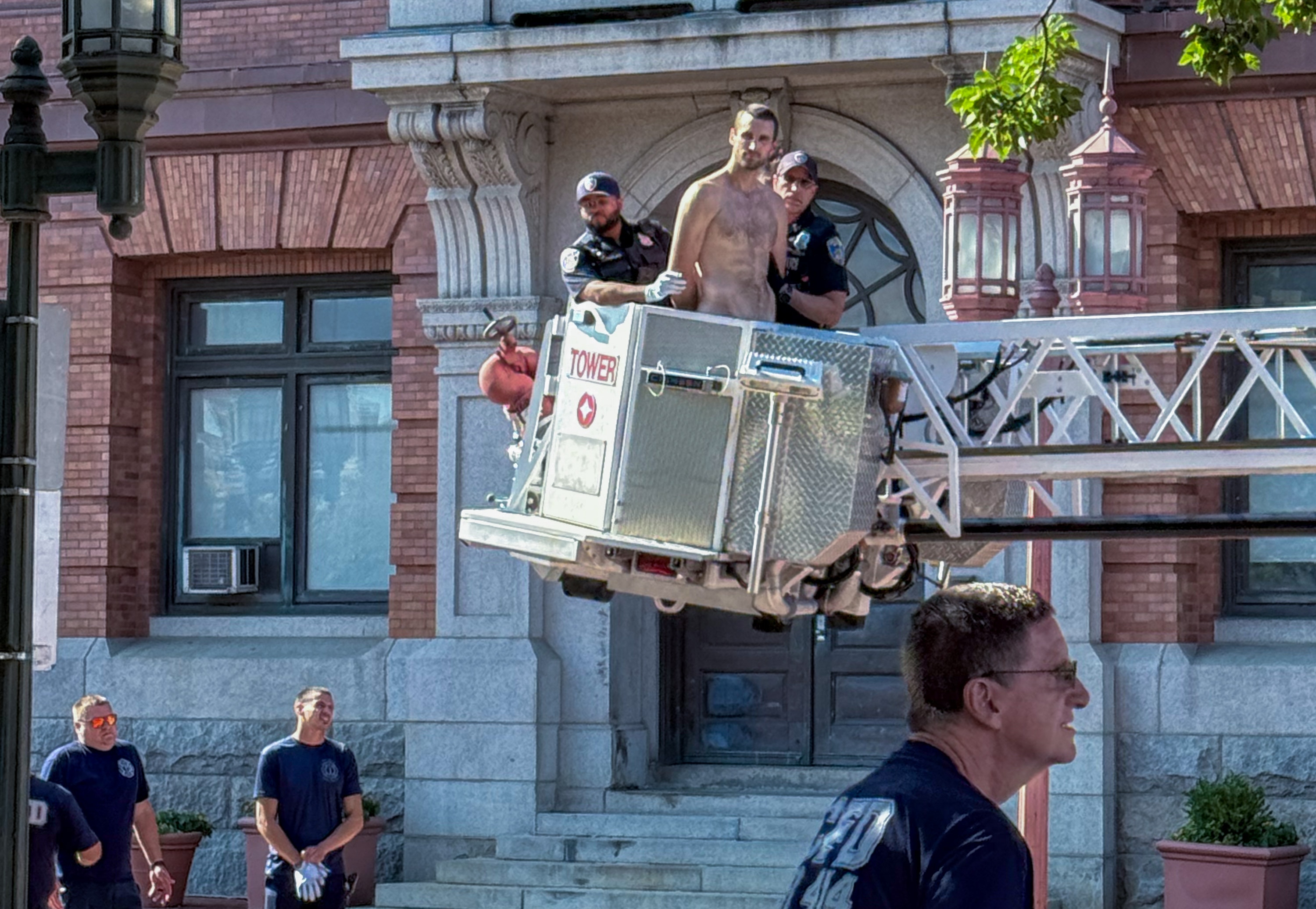 Saturday, July 4, 2026 — Baltimore Police take a naked man into custody after removing him from the Columbus pedestal near the Inner Harbor.