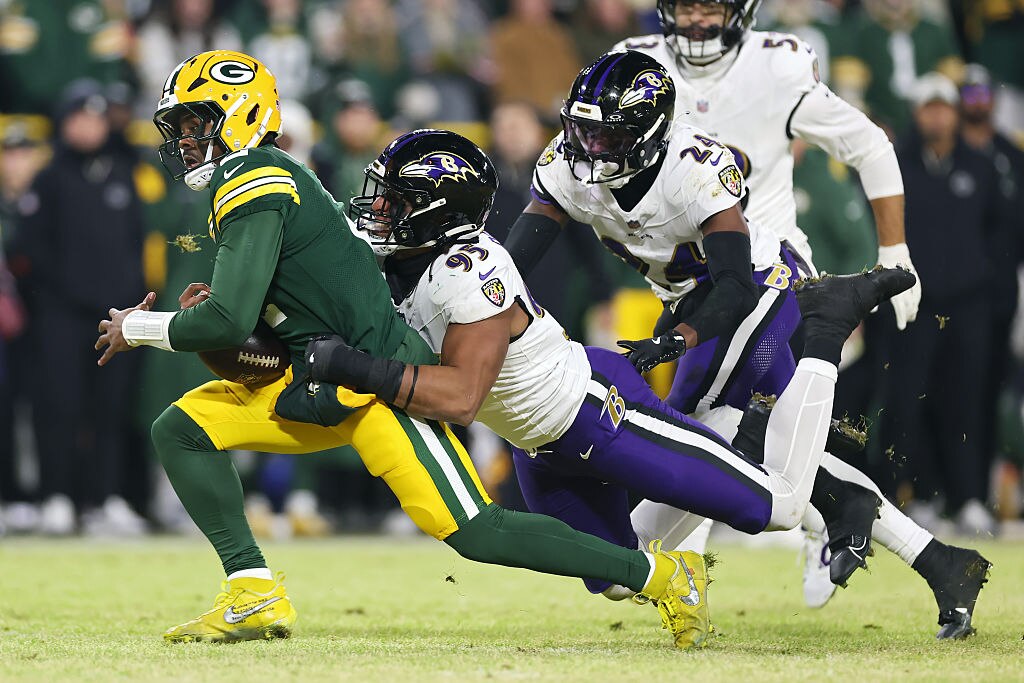 Green Bay Packers quarterback Malik Willis runs with the ball while being tackled by Baltimore Ravens outside linebacker Tavius Robinson in the third quarter.