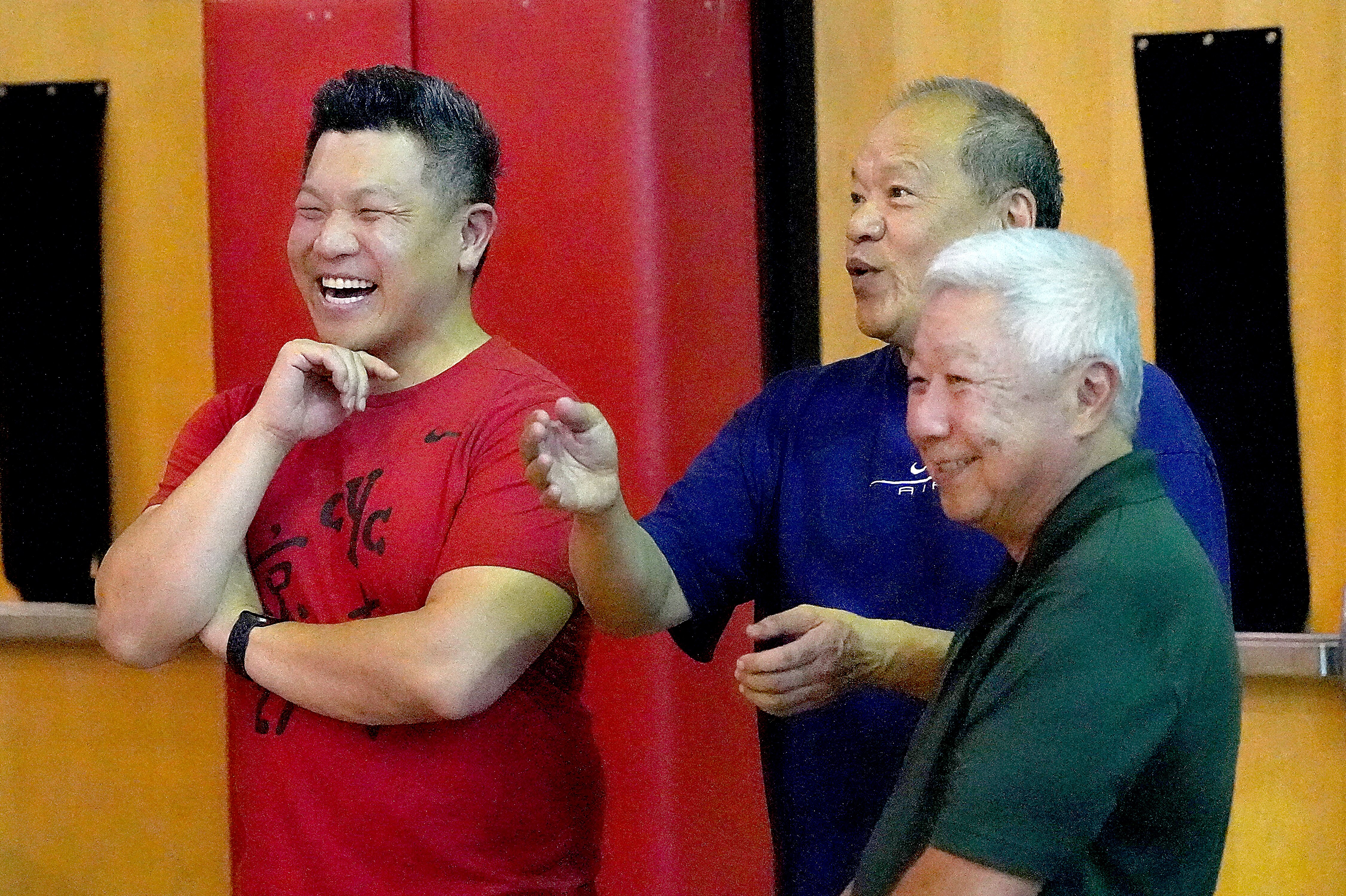Patrick Chin, 42, Rockville. Chin has been playing Chinese Volleyball since he was 15. (In green) John Chin, Patrick’s father is a former cyc (Chinese Youth Club) player.  Chin says that 9-man volleyball has helped to provide a sense of community a pride. *in blue) John Mon, also a former cyc player and former business partner to John chin, share a laugh as they watch the boys practice.