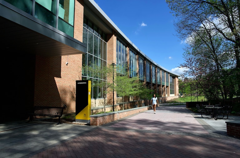 FRIDAY, APRIL 17, 2026 - A student walks past the Union, the Towson University community hub, located steps away from Tower C residence hall. A man accidentally shot himself in the leg in one of the dorm rooms the night prior. Police responded quickly and no students were injured.