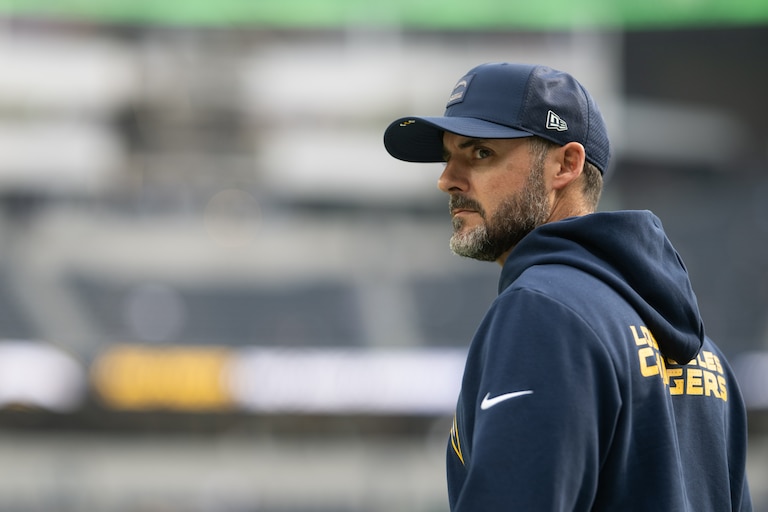 Los Angeles Chargers defensive coordinator Jesse Minter walks on the field before an NFL football game against the Las Vegas Raiders, Sunday, Nov. 30, 2025, in Inglewood, Calif.