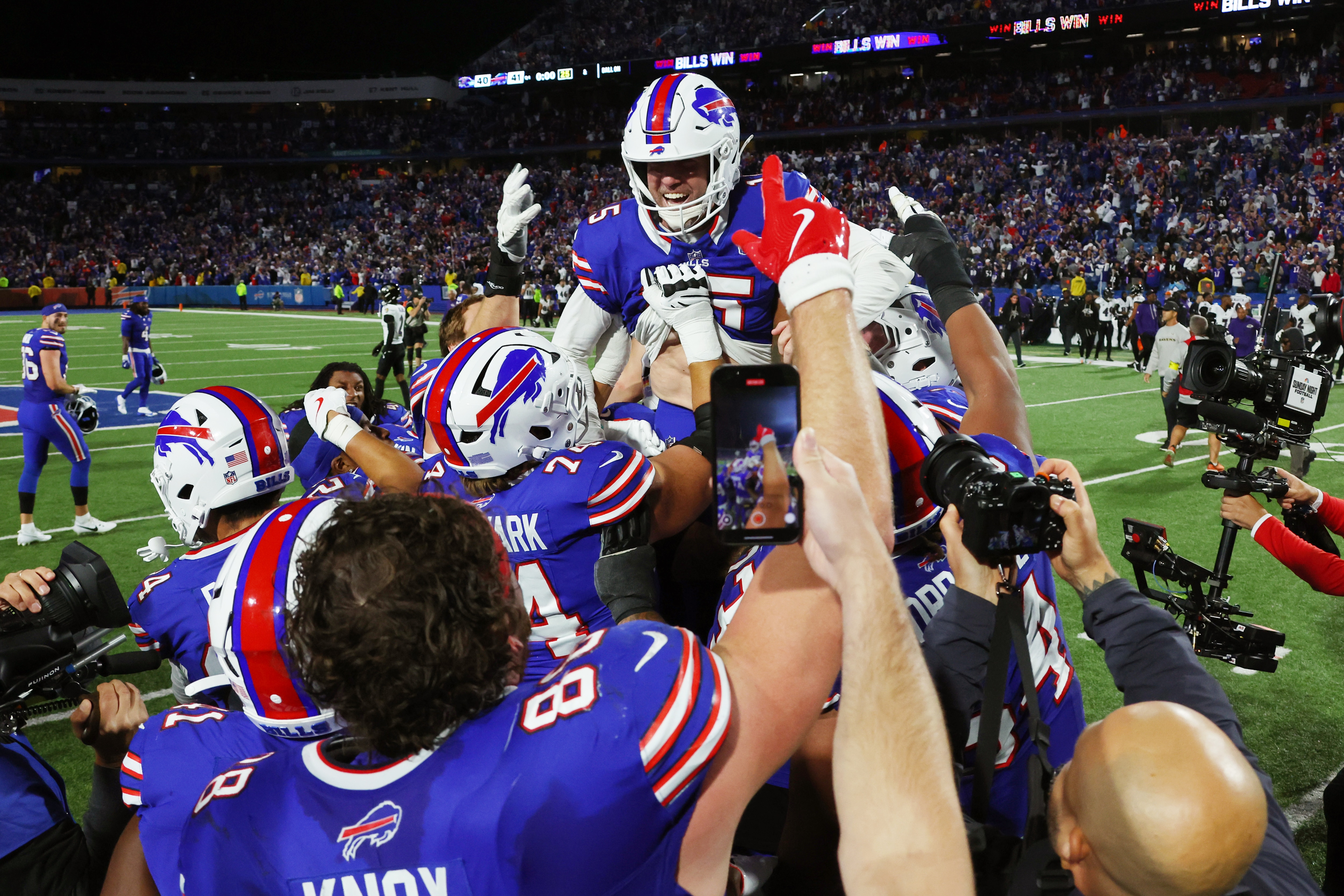 Bills players rush kicker Matt Prater after he made the winning field goal Sunday night.