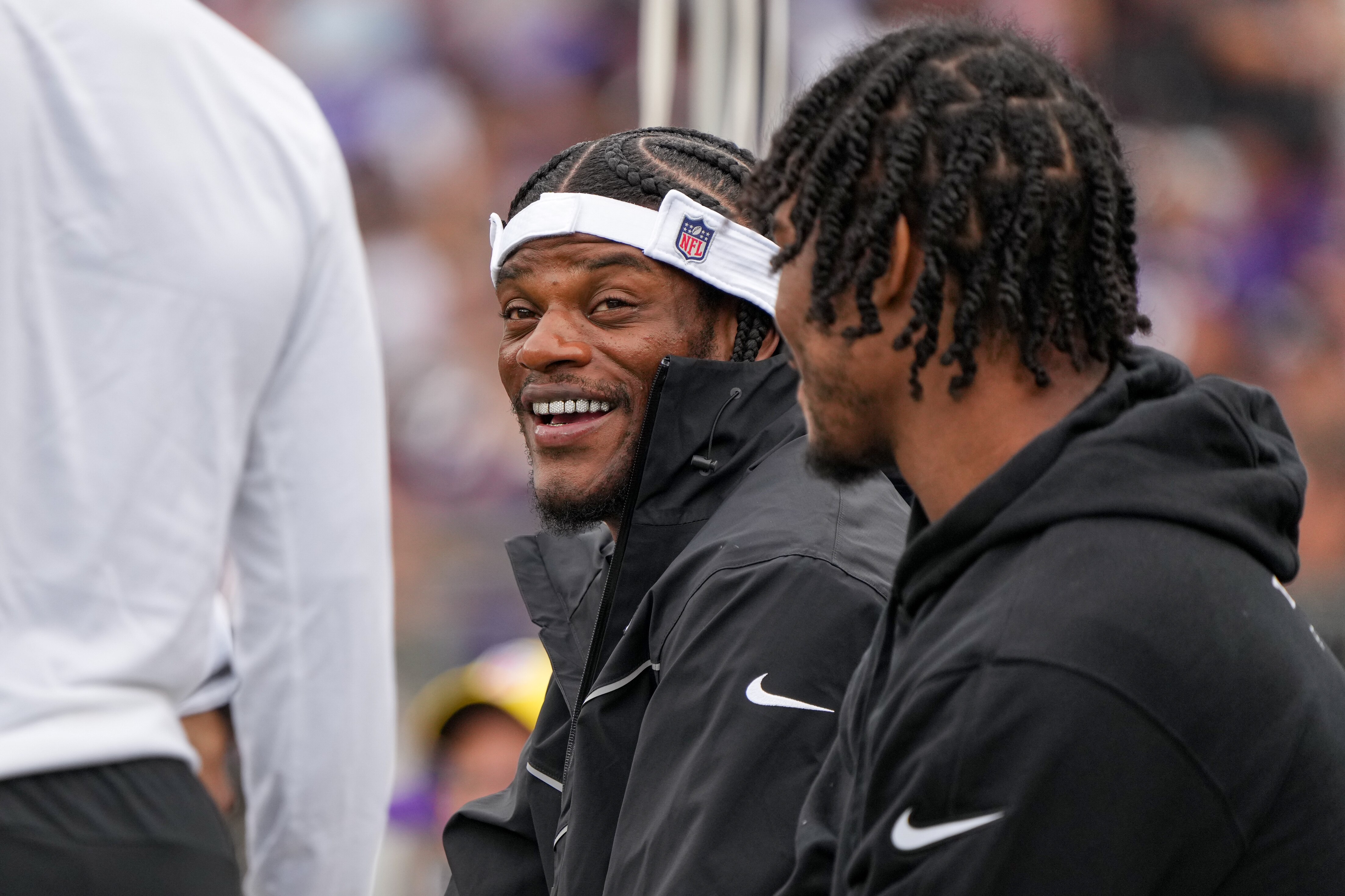 Baltimore Ravens quarterback Lamar Jackson laughs with teammates on the sidelines during a preseason game against the Atlanta Falcons at M&T Bank Stadium in Baltimore on August 17, 2024.