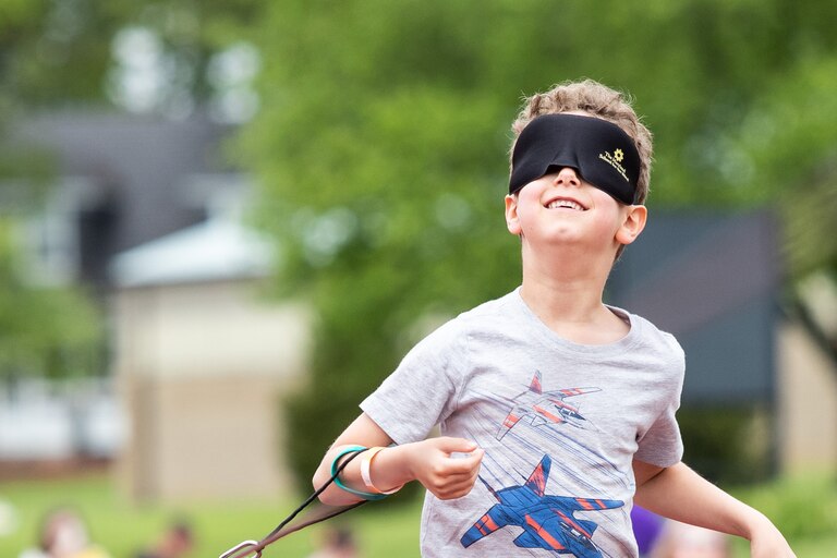 A young boy runs on The Maryland School for the Blind sprint track, with eyeshades, at the See Beyond festival.