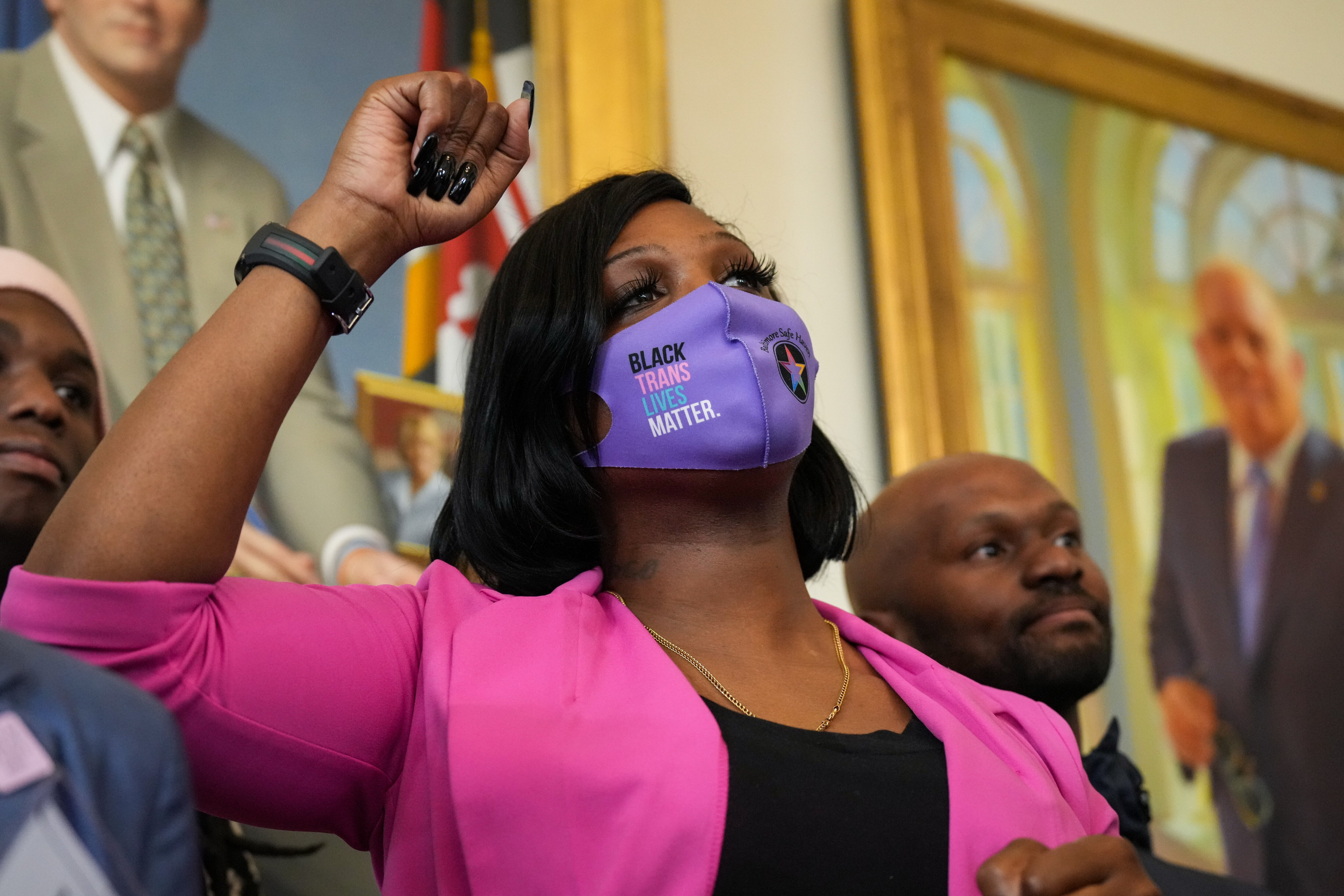 Iya Dammons, executive director of Baltimore Safe Haven, raises her fist in the air as Gov. Wes Moore proclaims March 31, 2023 International Trans Visibility Day in Maryland during a press conference in the State House. Dammons and dozens of other trans rights advocates traveled to Annapolis Friday to show their support for the proclamation.
