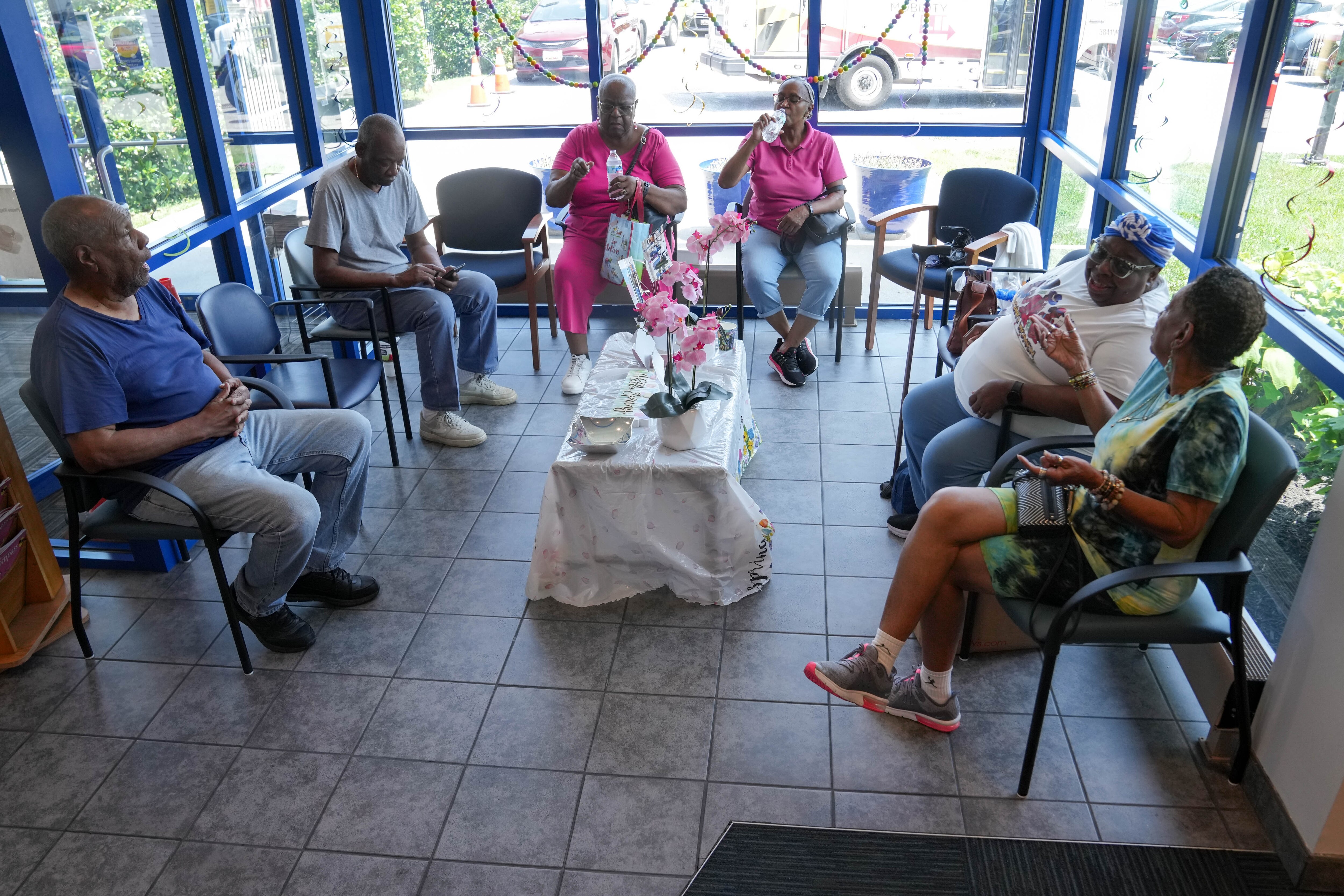 Local residents relax inside the lobby of the Zeta Center for Healthy and Active Aging, one of the Baltimore City Health Department’s cooling centers, in northwest Baltimore on Monday.