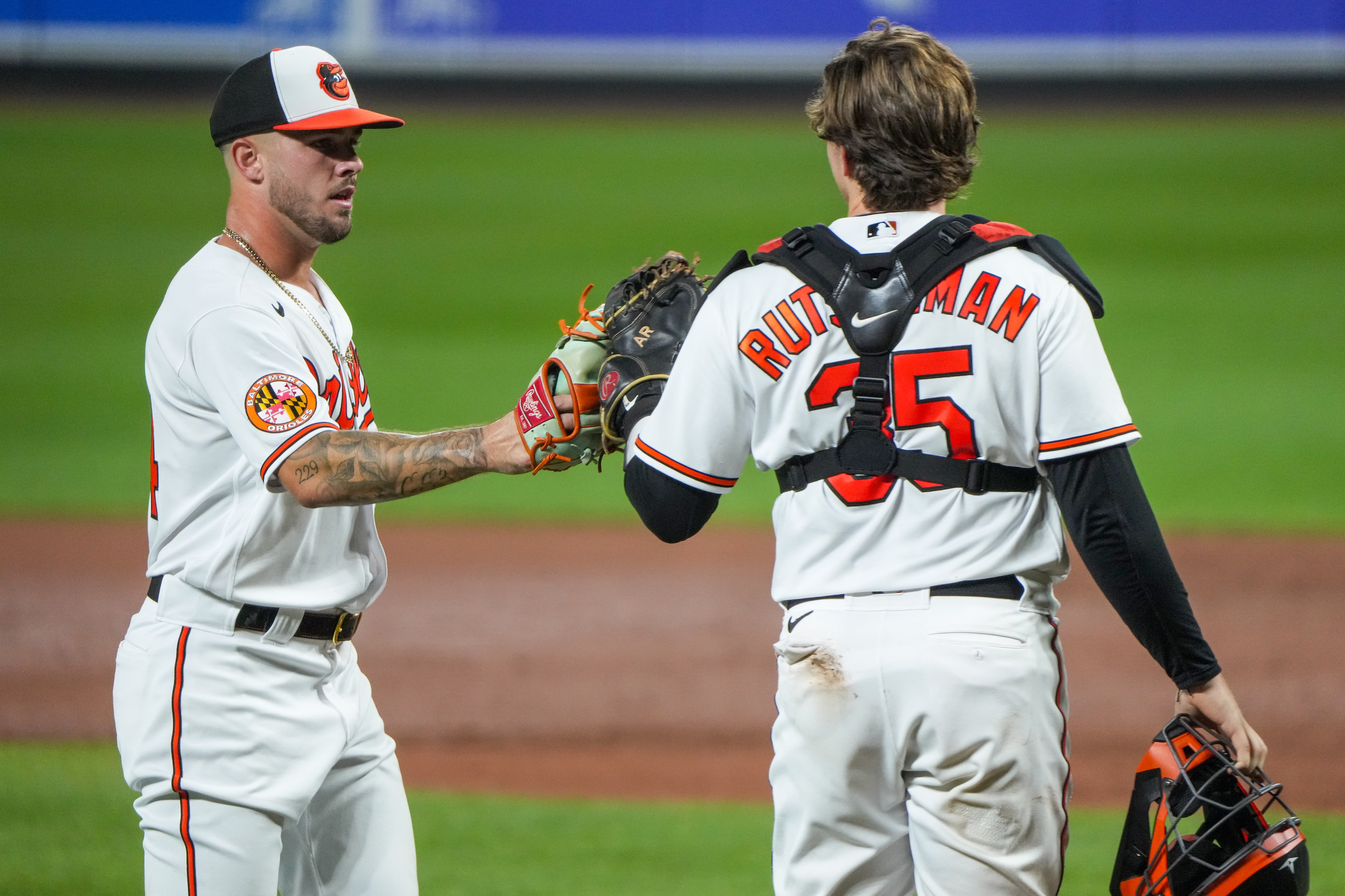 Baltimore Orioles relief pitcher DL Hall (24) fist bumps catcher Adley Rutschman (35) as they return to the dugout during a baseball game against the Chicago White Sox at Camden Yards on Monday, Aug. 28.