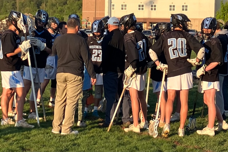 Westminster's boys lacrosse team gathers during a timeout in Tuesday evening's match at Winters Mill. The Owls remained undefeated in Carroll County Athletic League play with a 9-7 victory over the Falcons.